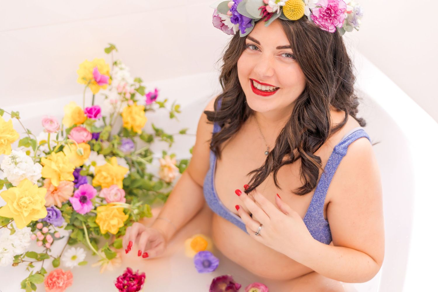 Joyful spring-themed portrait with flower crown and colorful floral arrangements.