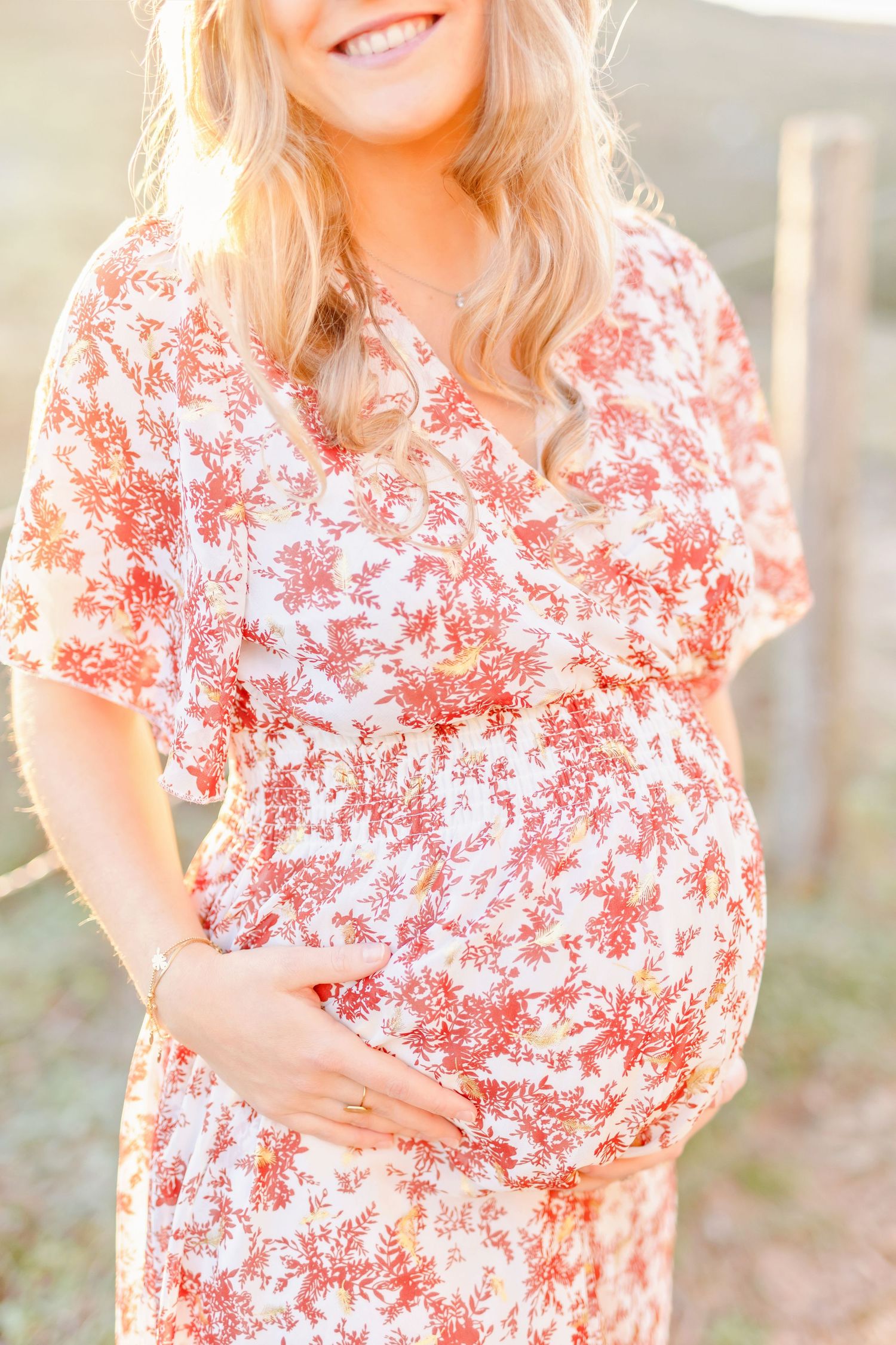 A close-up portrait showing a floral dress against a sun-drenched natural backdrop.