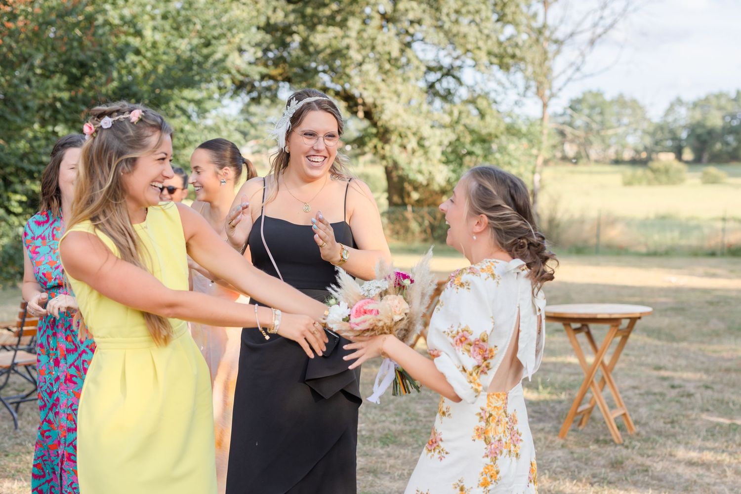 Outdoor wedding celebration shows guests enjoying festivities in summer attire.