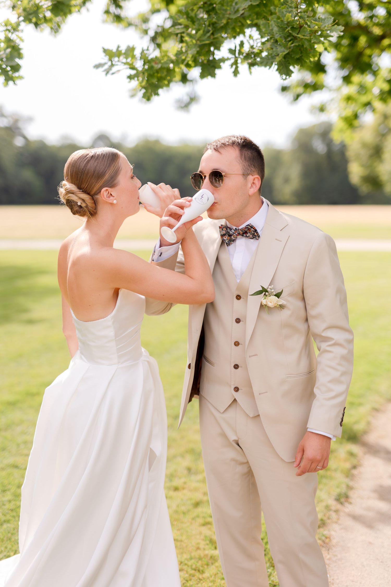 Romantic wedding photo sequence shows couple playfully drinking from wine glasses outdoors.