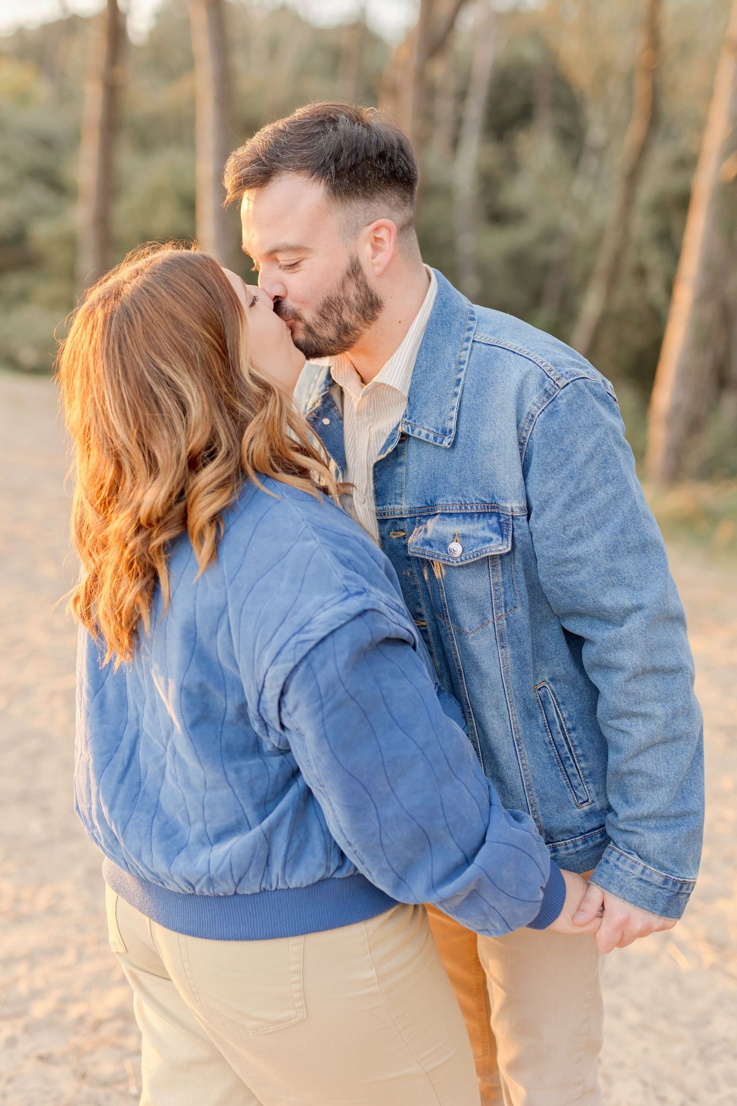 Sunset beach portraits of couple in matching denim jackets.