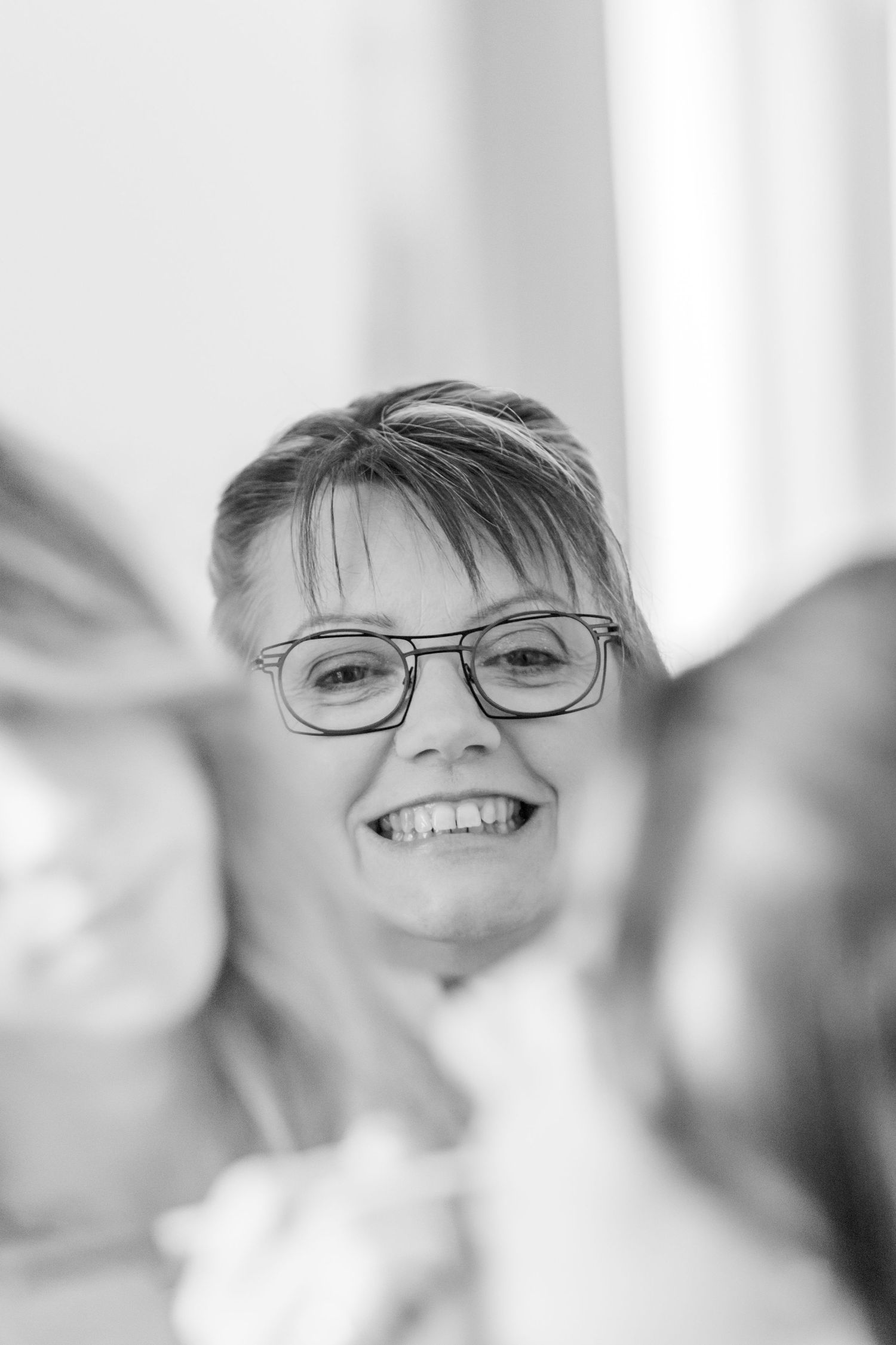 Black and white portrait showing joyful expressions during a wedding preparation.