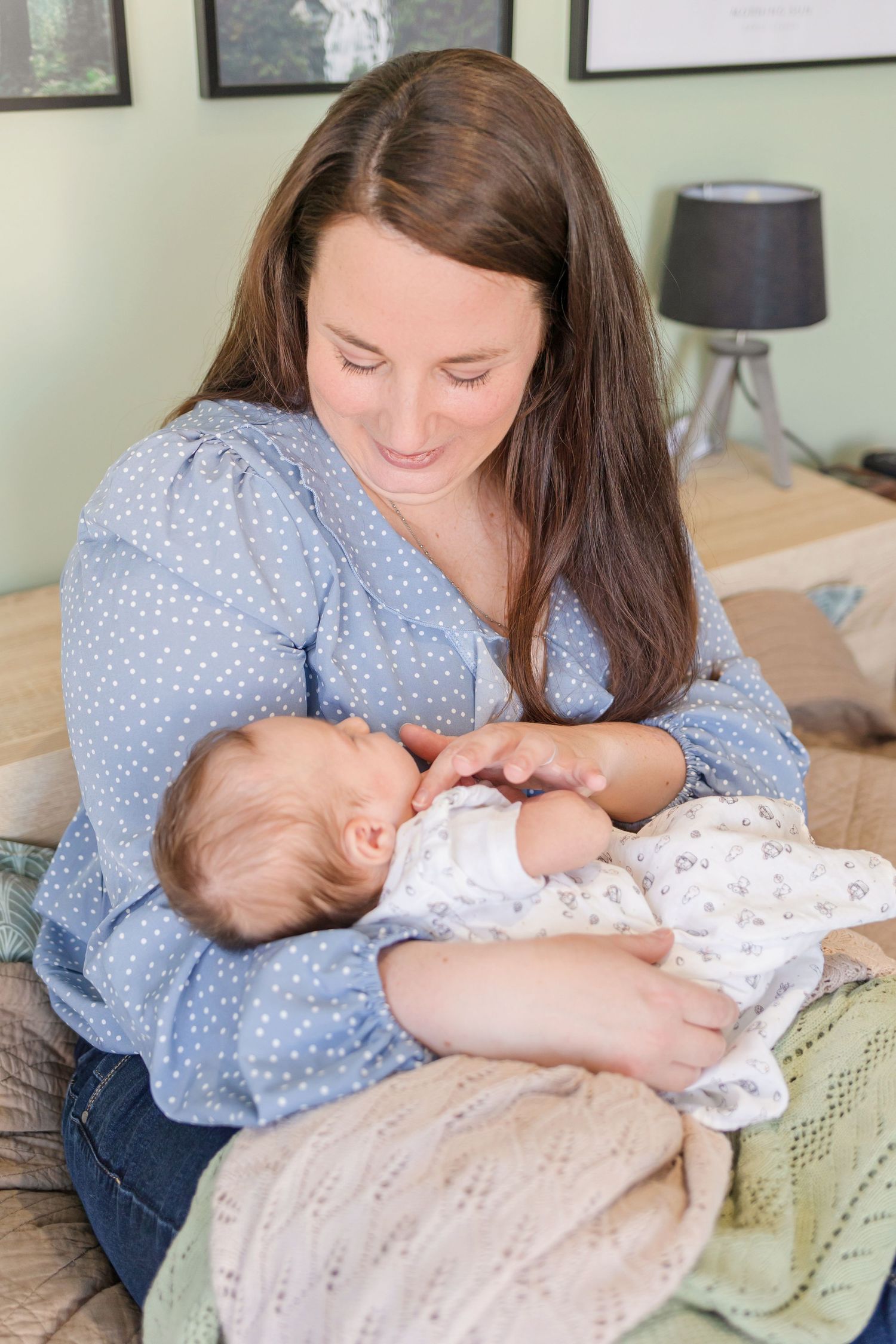 Sweet bonding moment between parent and infant on couch with soft lighting.