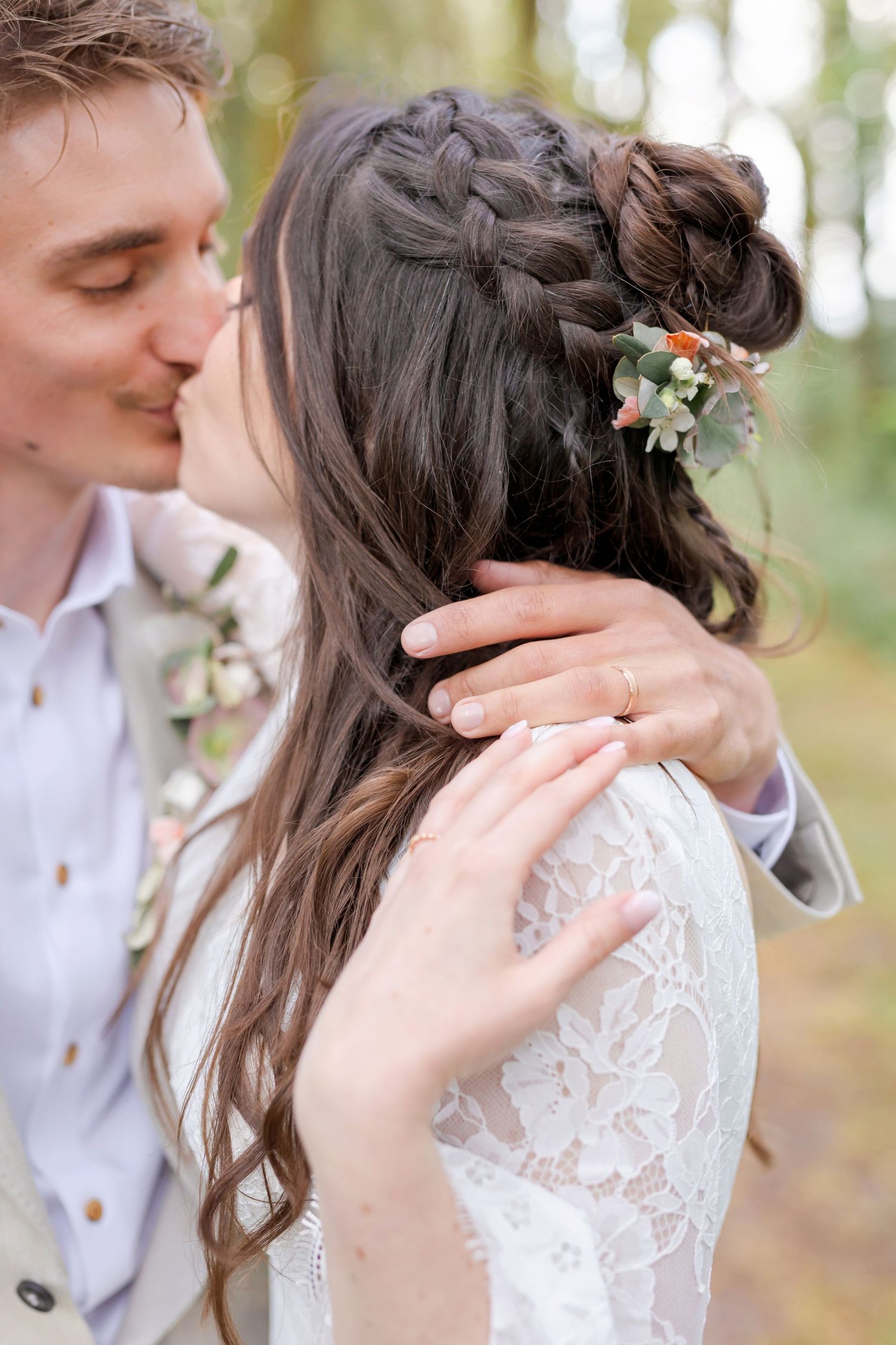 Close-up wedding portrait showing romantic moments between bride and groom in a wooded setting.