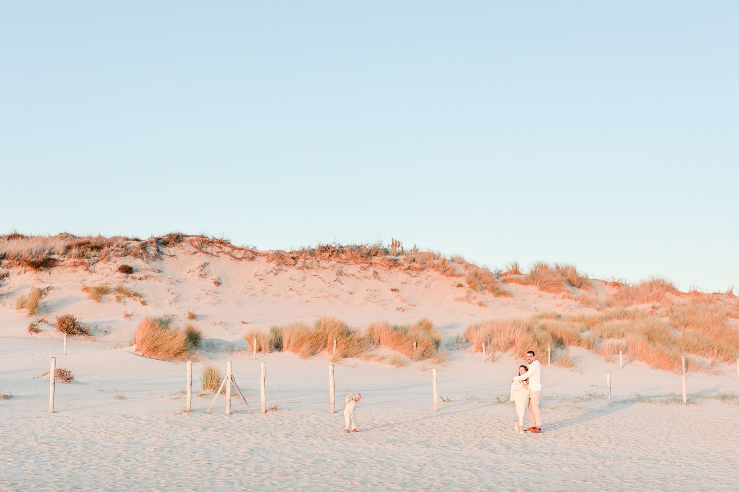 Sandy dunes stretch along a peaceful beach landscape at dusk.