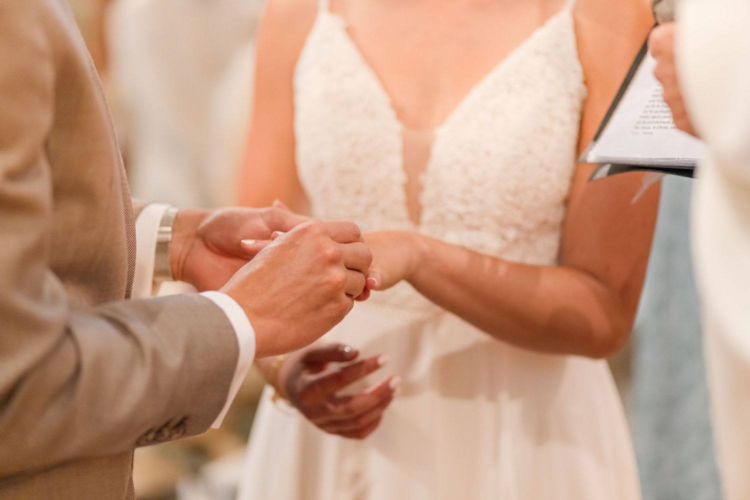 Intimate moment of ring exchange during traditional church wedding ceremony.