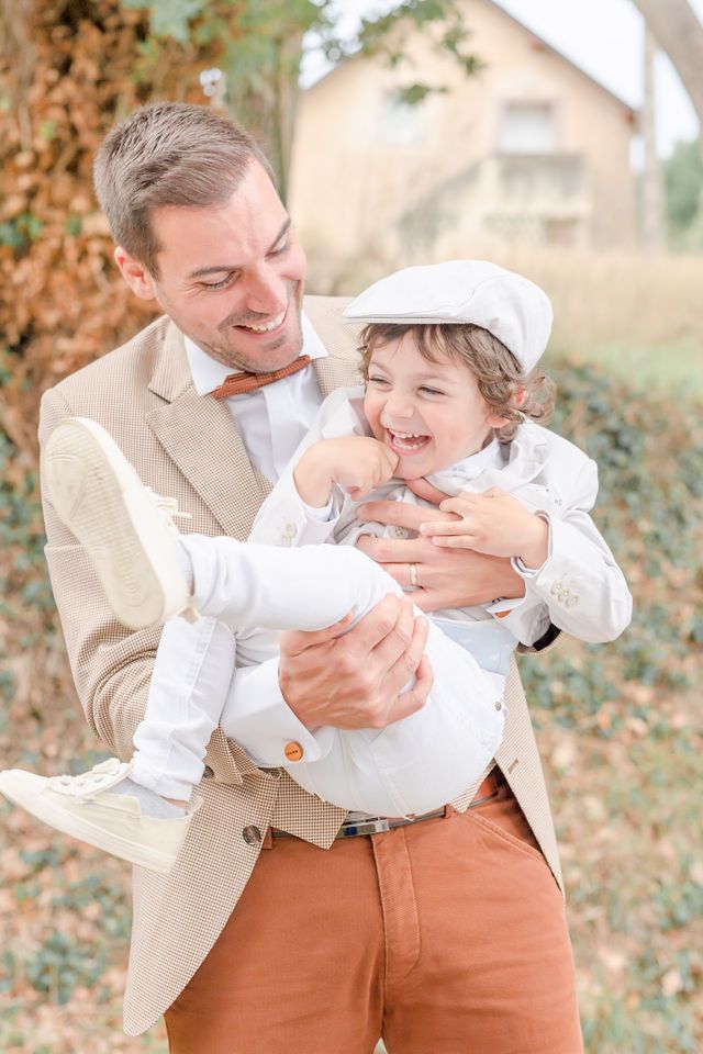 Joyful family moment captured against fall foliage.
