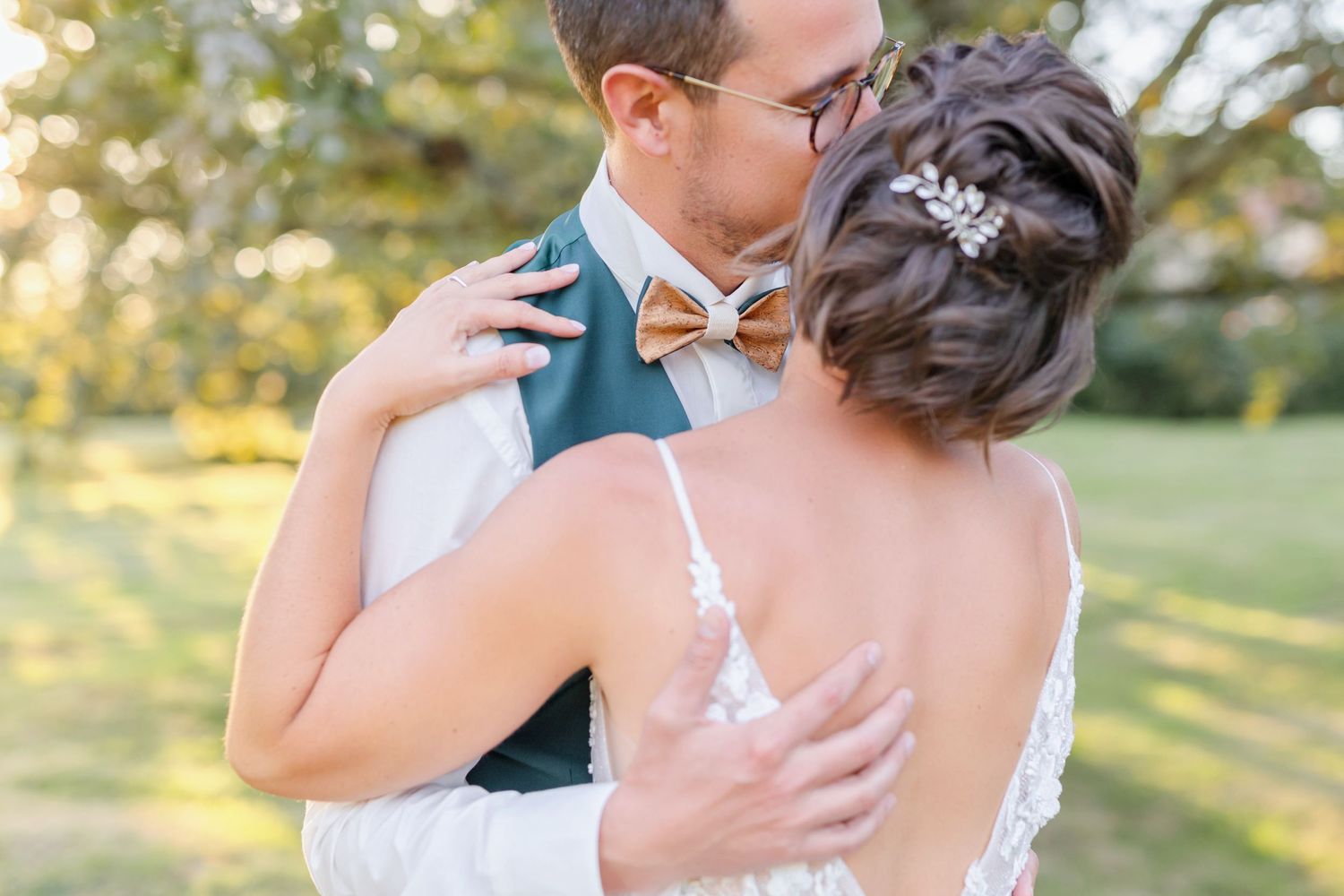A tender embrace between newlyweds in a garden setting at golden hour.