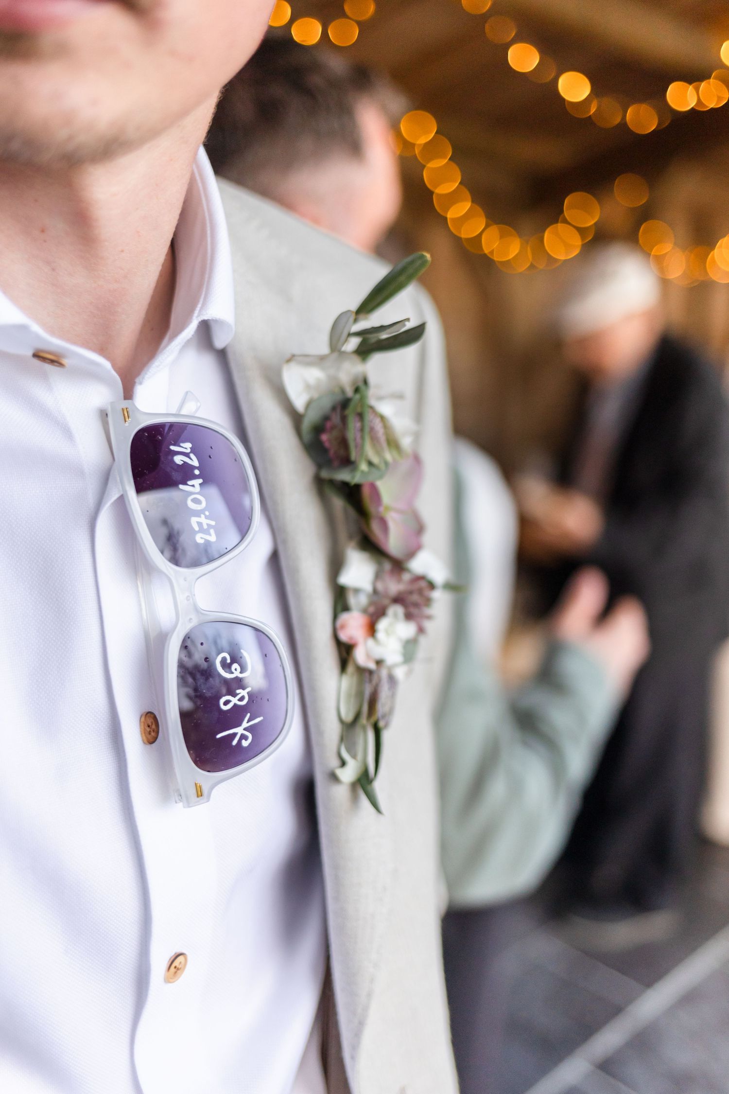 Detail of wedding attire showing purple name badges and floral boutonniere.
