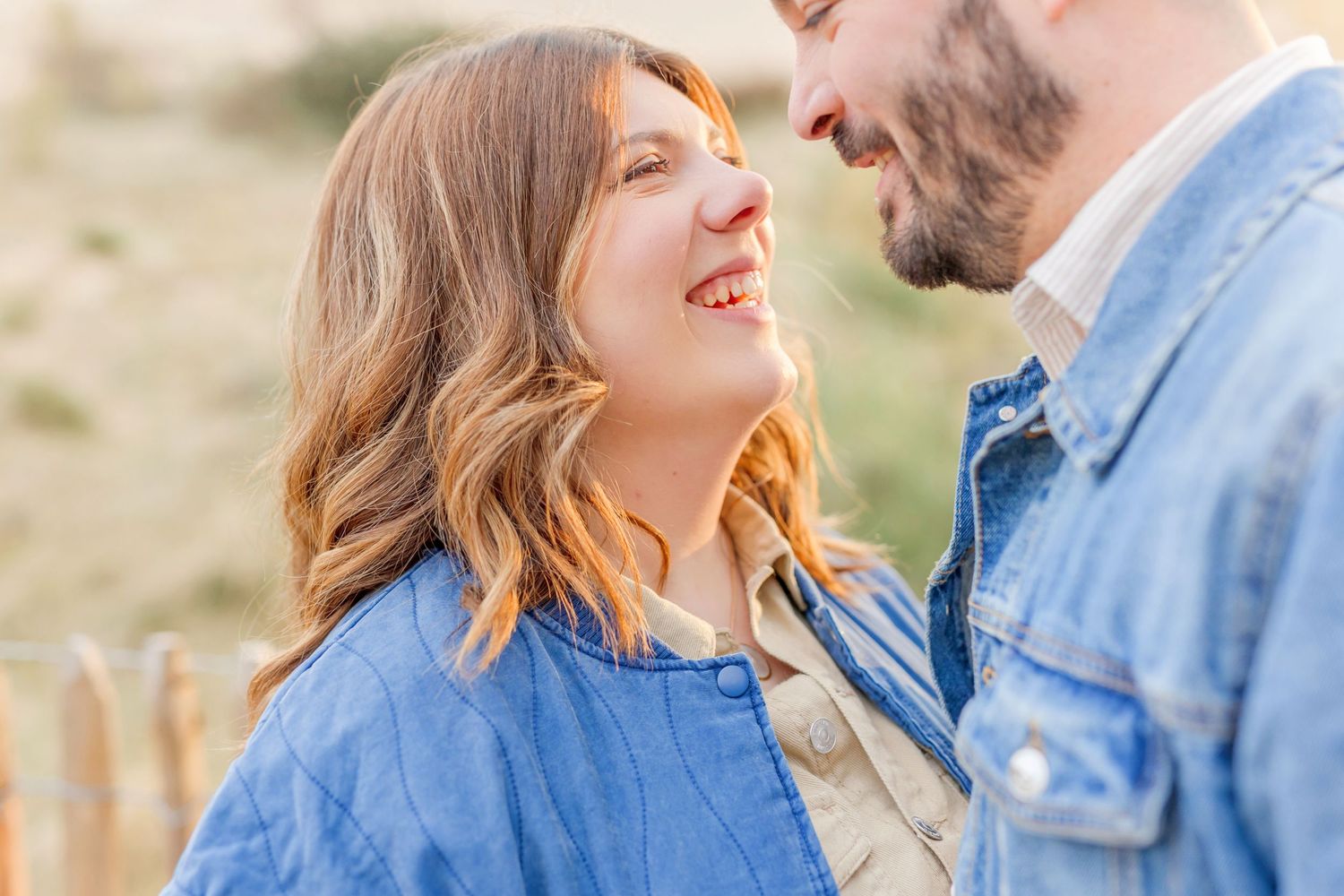 Joyful moment captured between couple wearing matching blue jackets outdoors.