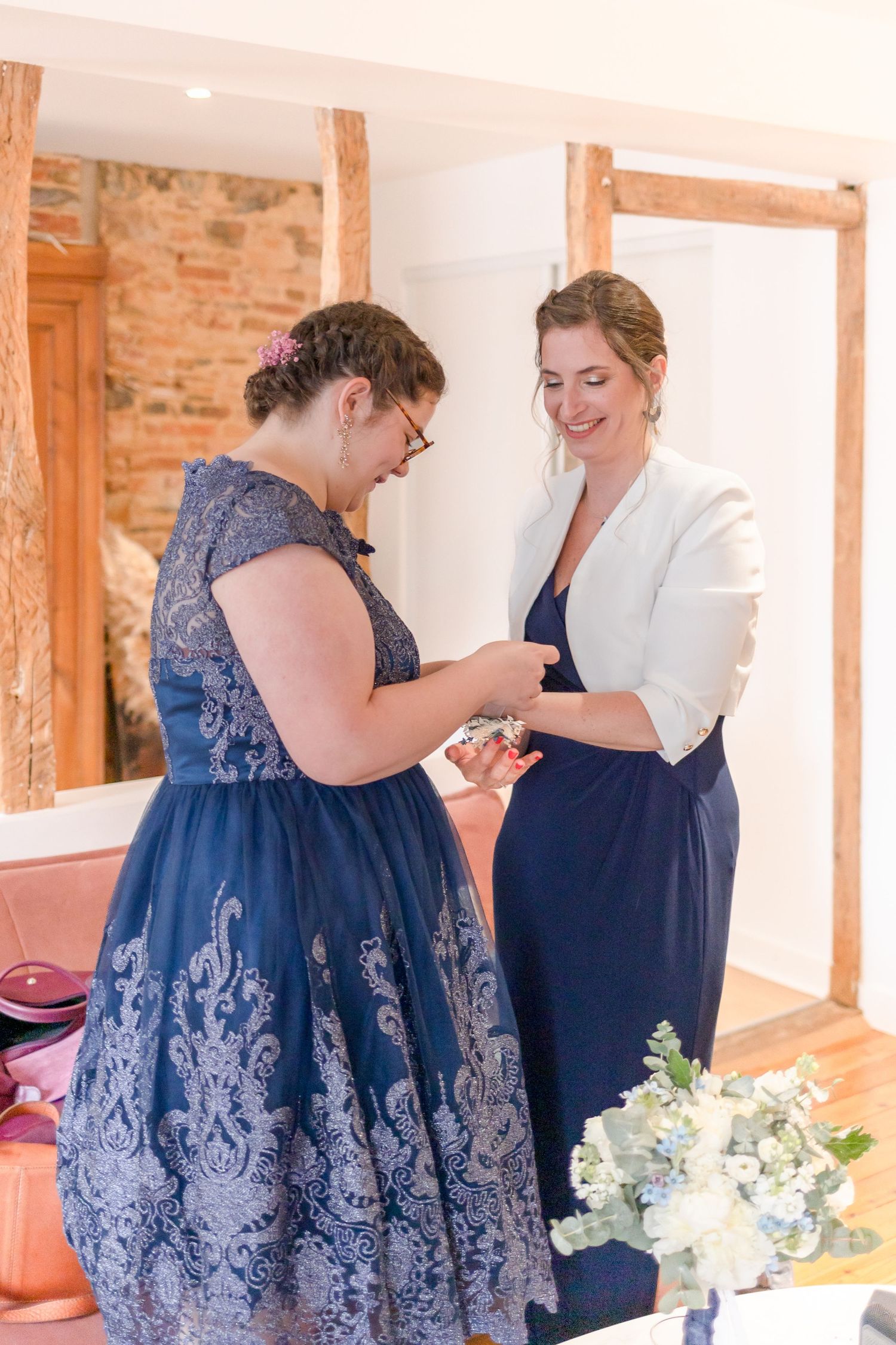 Two people sharing a sweet moment while getting ready in a room with exposed brick walls.