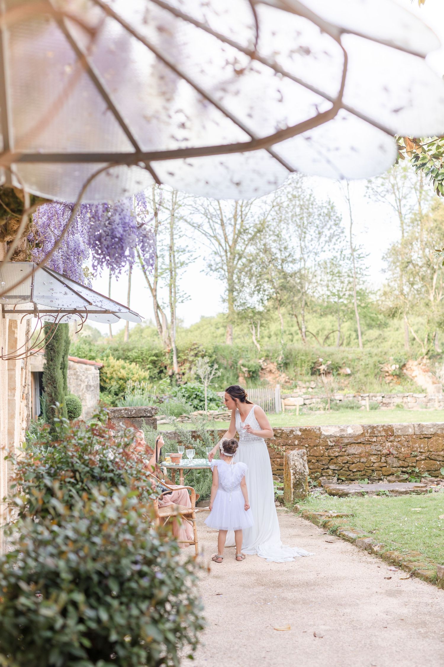 Garden pathway with blooming wisteria and stone walls at rustic venue.