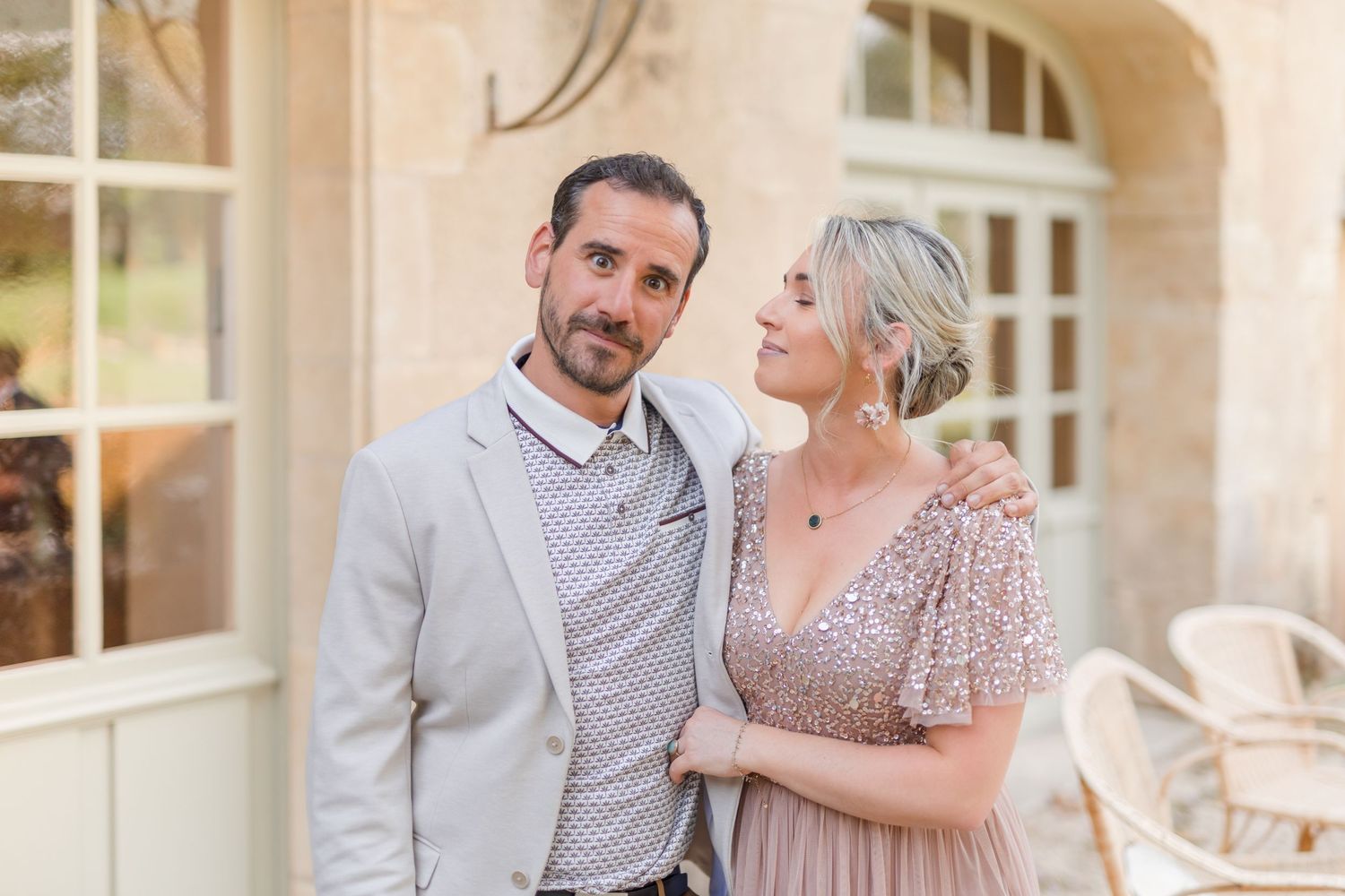 Couple embracing and laughing together on a stone patio.