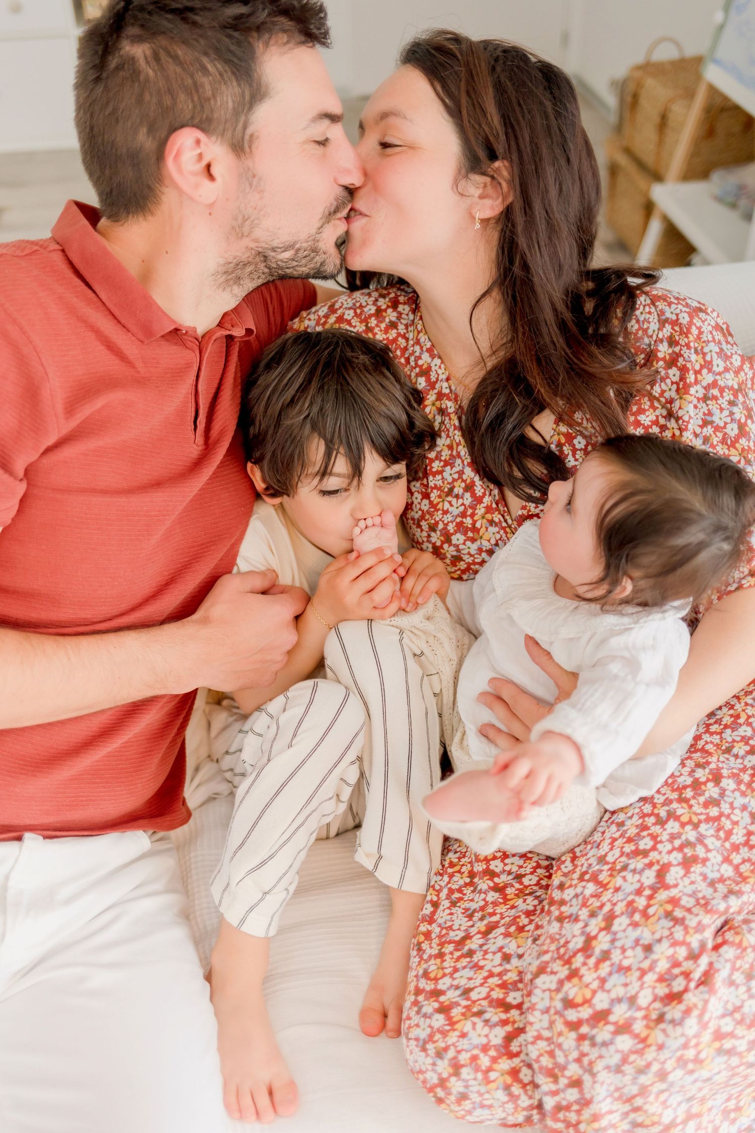 Sweet family moments captured on white bedding with coral and floral accents.
