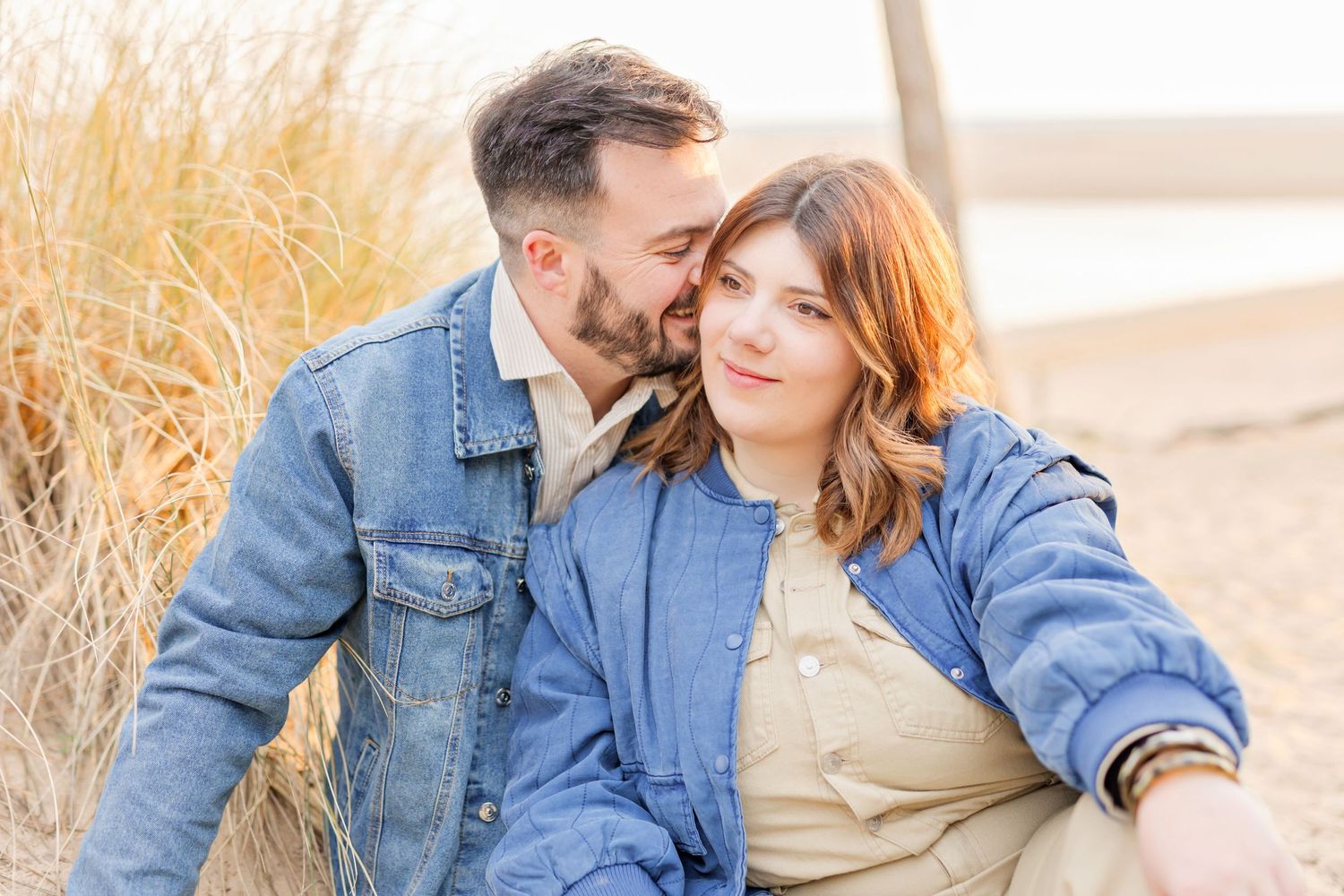 Intimate beach portraits of couple in casual denim and neutral clothing.