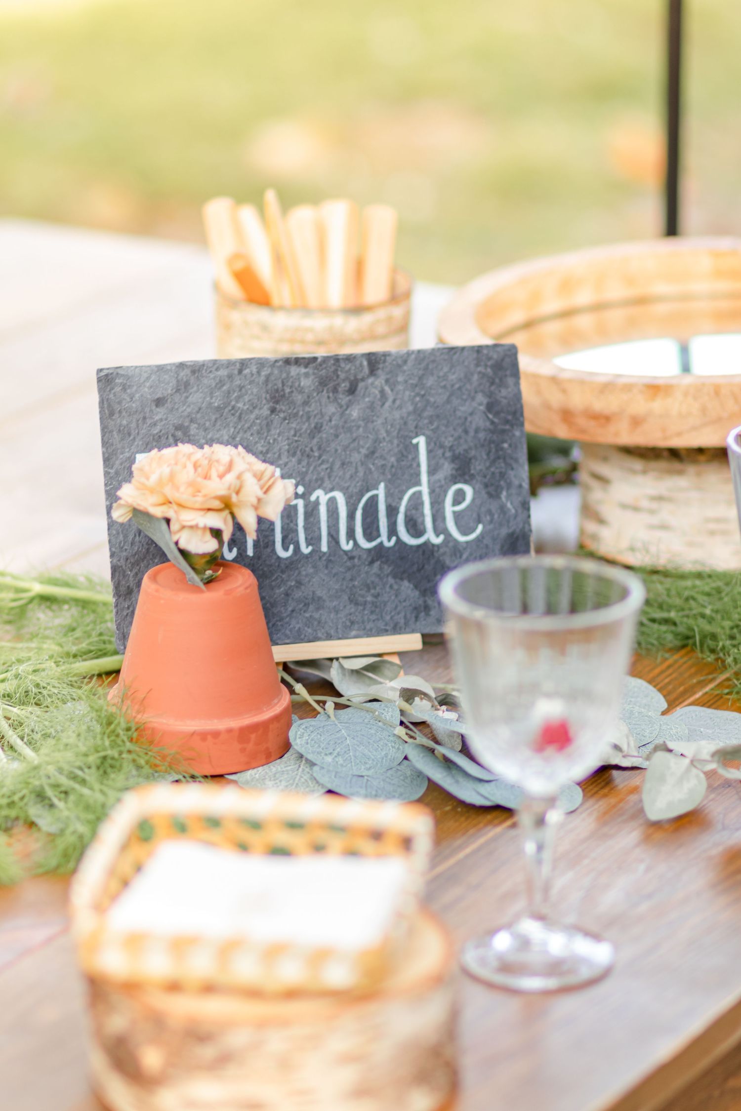 Rustic wedding table setting with slate signs and peach-colored decorative accents.