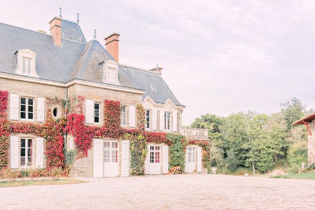 Exterior view of a traditional French country estate with ivy-covered walls.