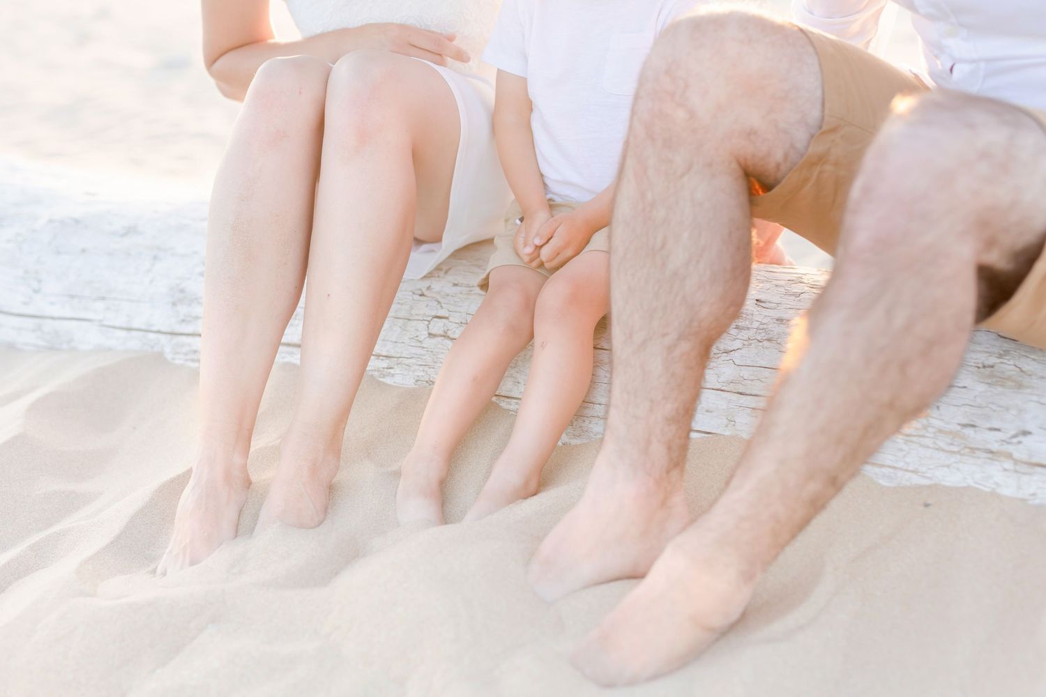 Relaxed feet and legs dangling over the edge of a sandy beach ridge.