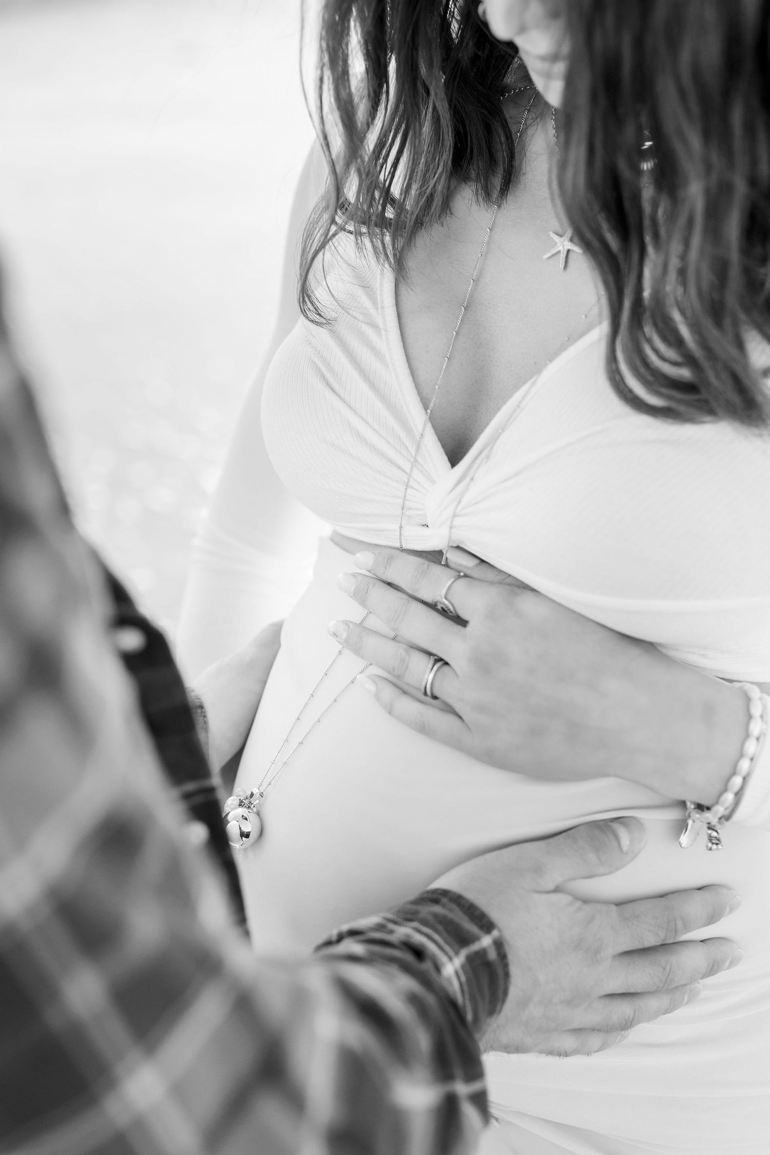 Black and white maternity photos capture gentle moments and baby bump caresses.