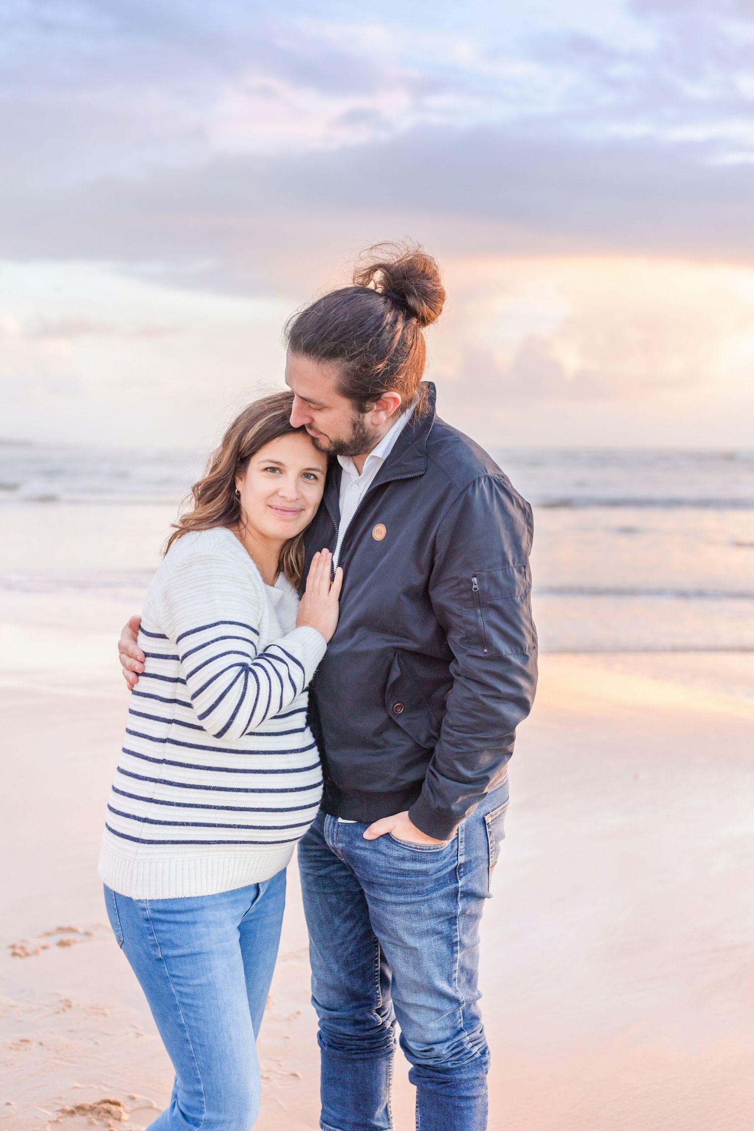 Intimate beachside maternity portraits with couple during golden hour.