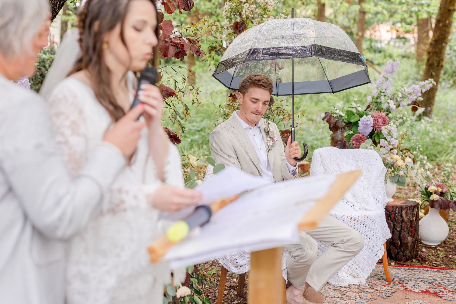 Guests participate in readings during an intimate outdoor woodland wedding ceremony.