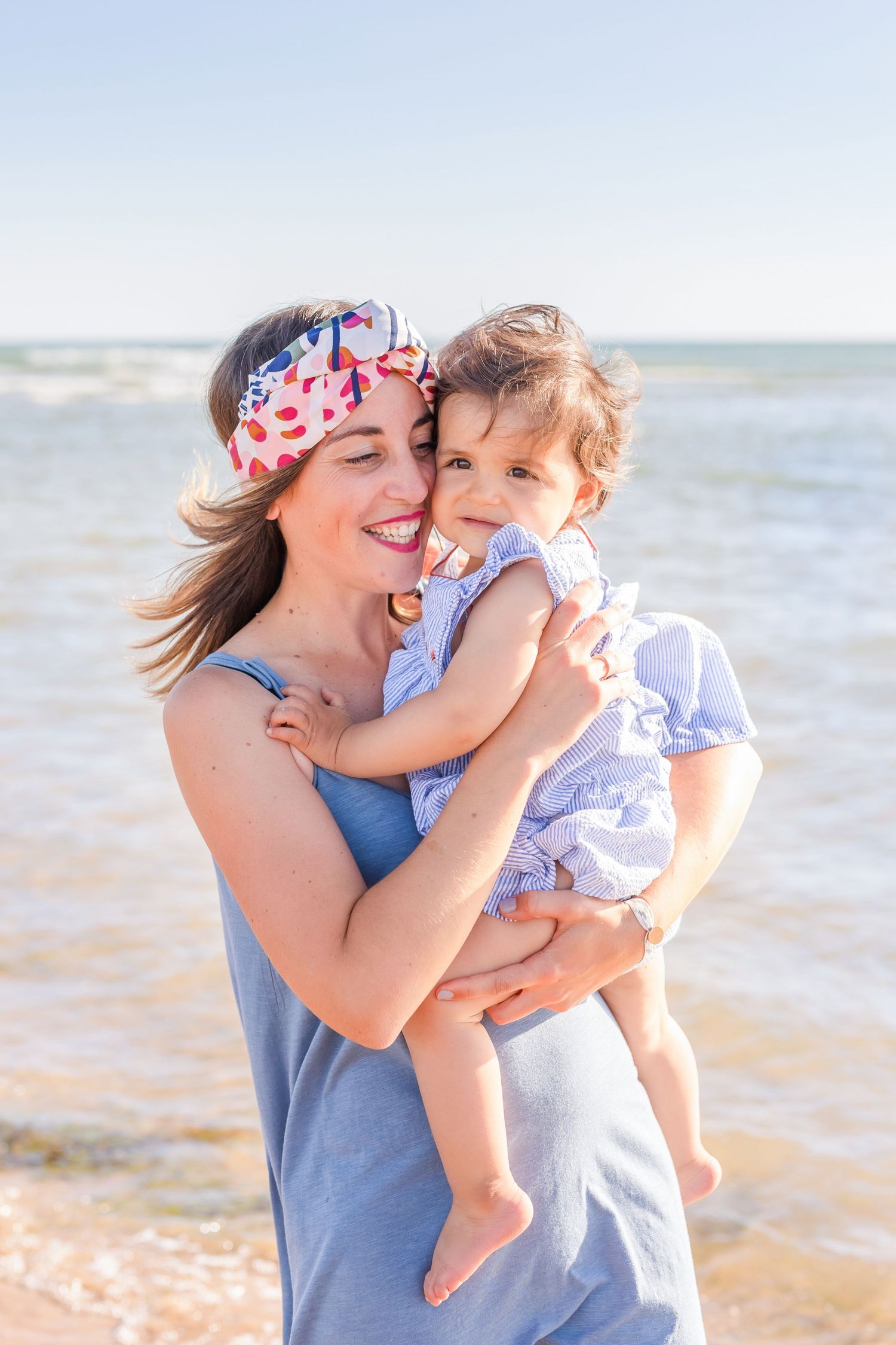 Tender embrace shared between parent and child on sunny beach.
