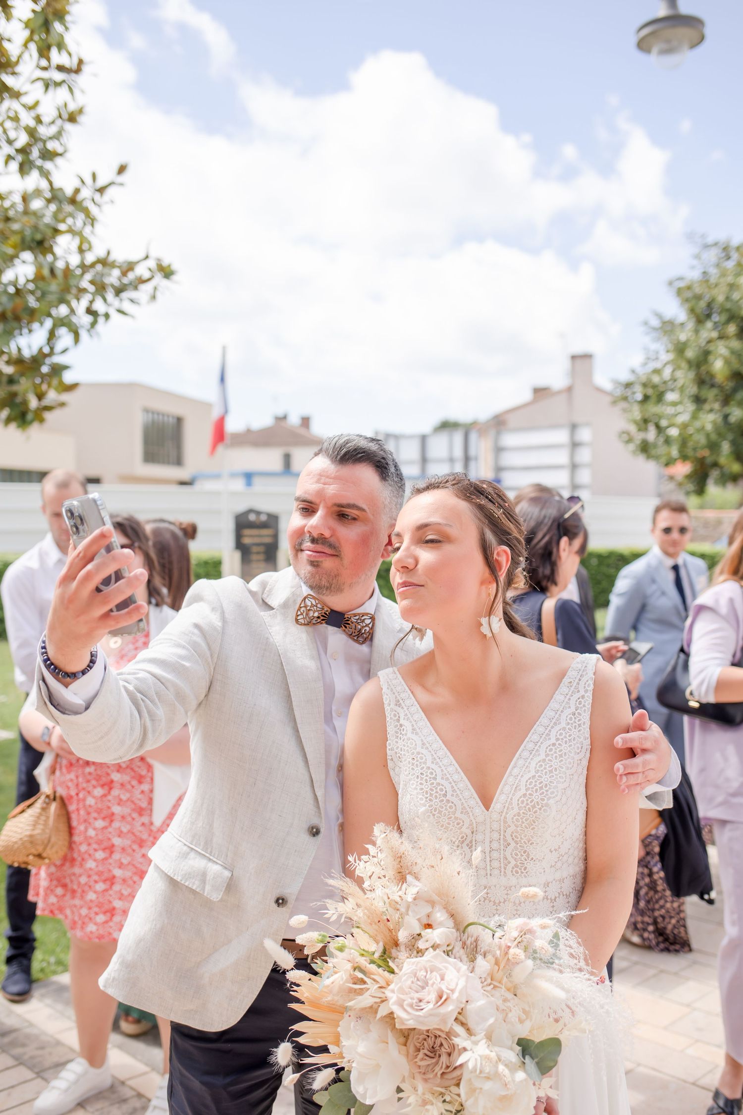 Wedding celebration guests toasting with drinks in an outdoor setting.
