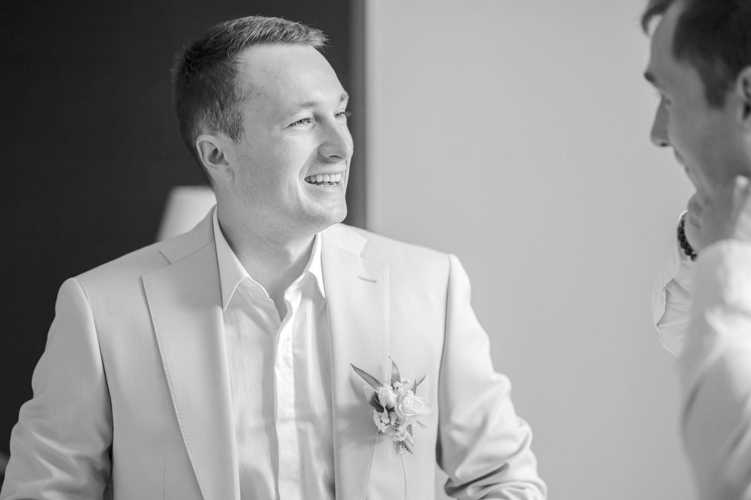 Black and white photo of formal wedding attire and boutonniere details.