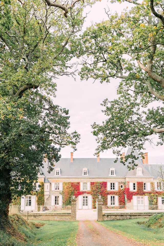 Majestic country estate with grand architecture framed by leafy trees.