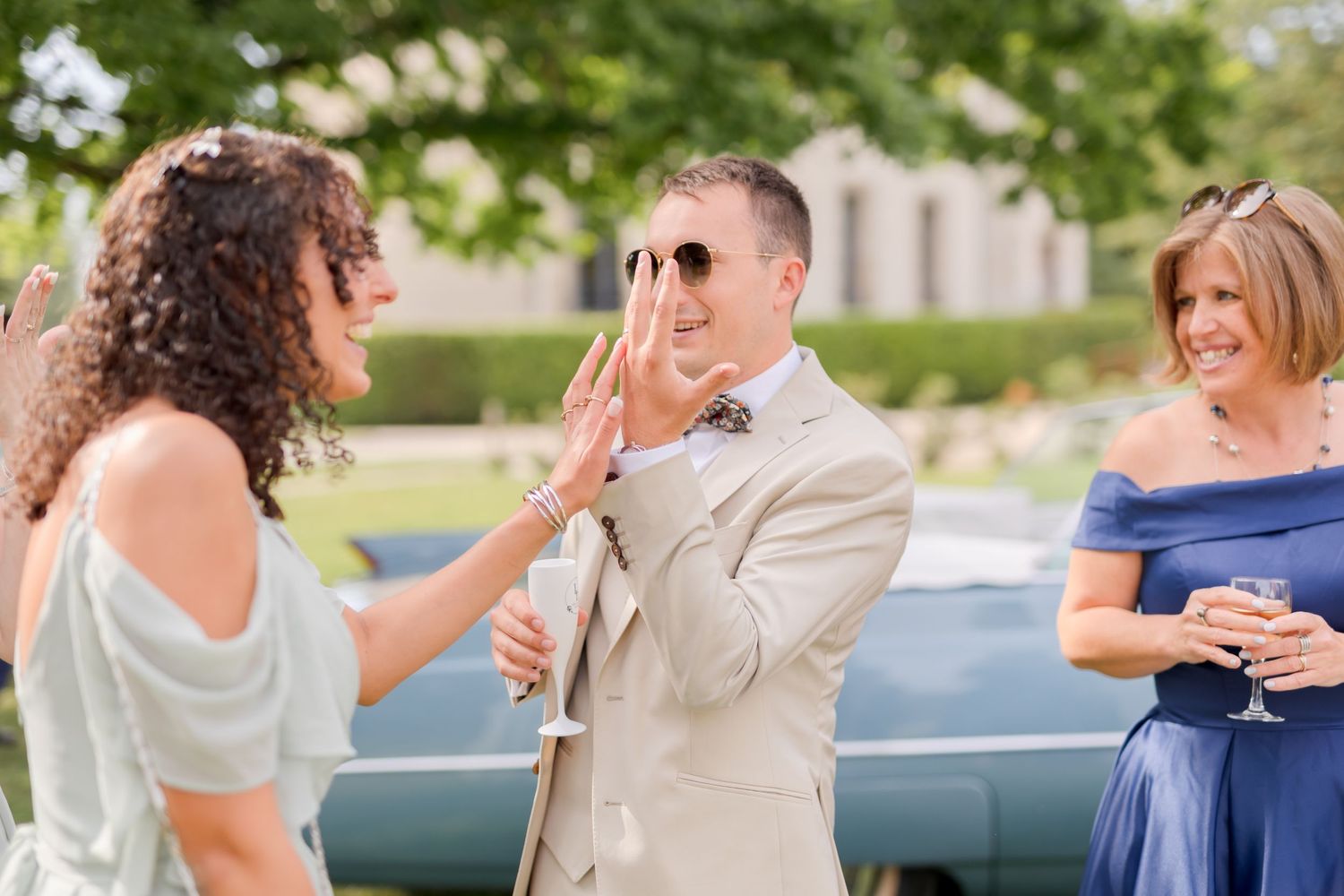 Wedding guests chatting and laughing at outdoor reception.