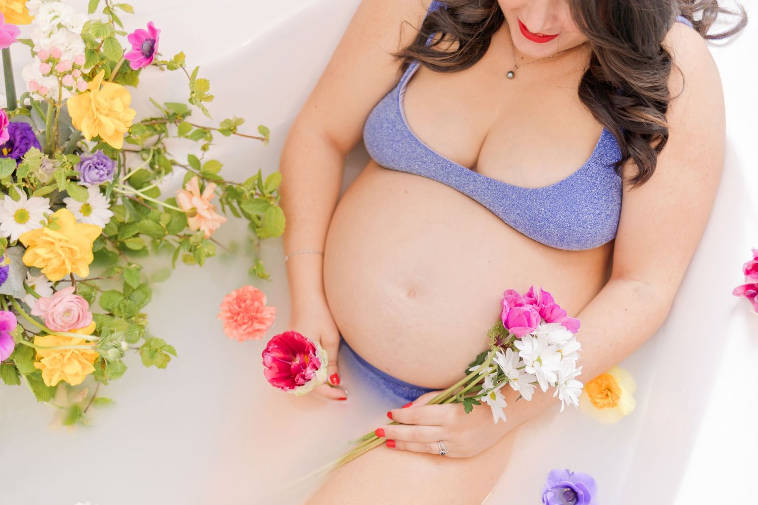 Artistic boudoir photography with vibrant flower arrangements on white background.
