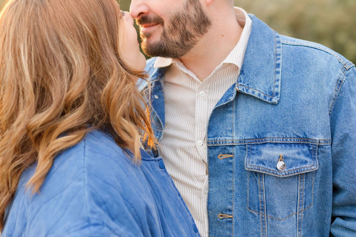 Close-up detail of couple in denim jackets during intimate outdoor photoshoot.