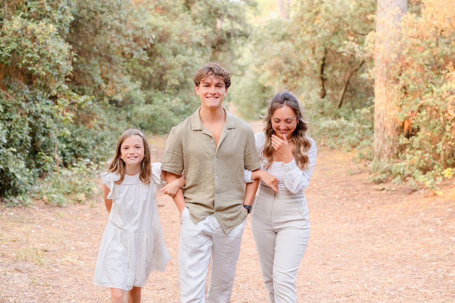 A cheerful group in coordinating outfits shares candid moments on a wooded path.