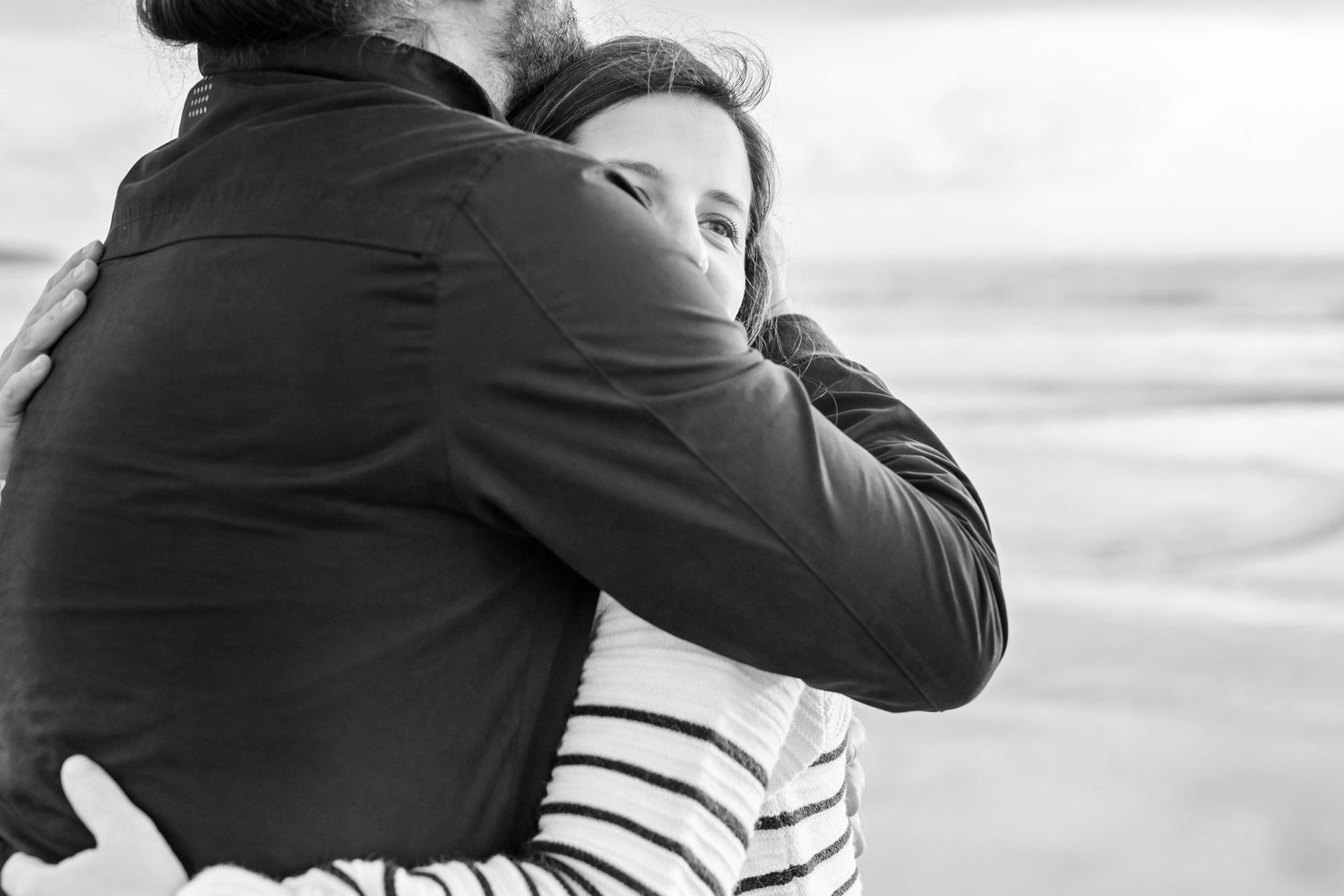 Black and white series of intimate couple portraits during beach maternity session.