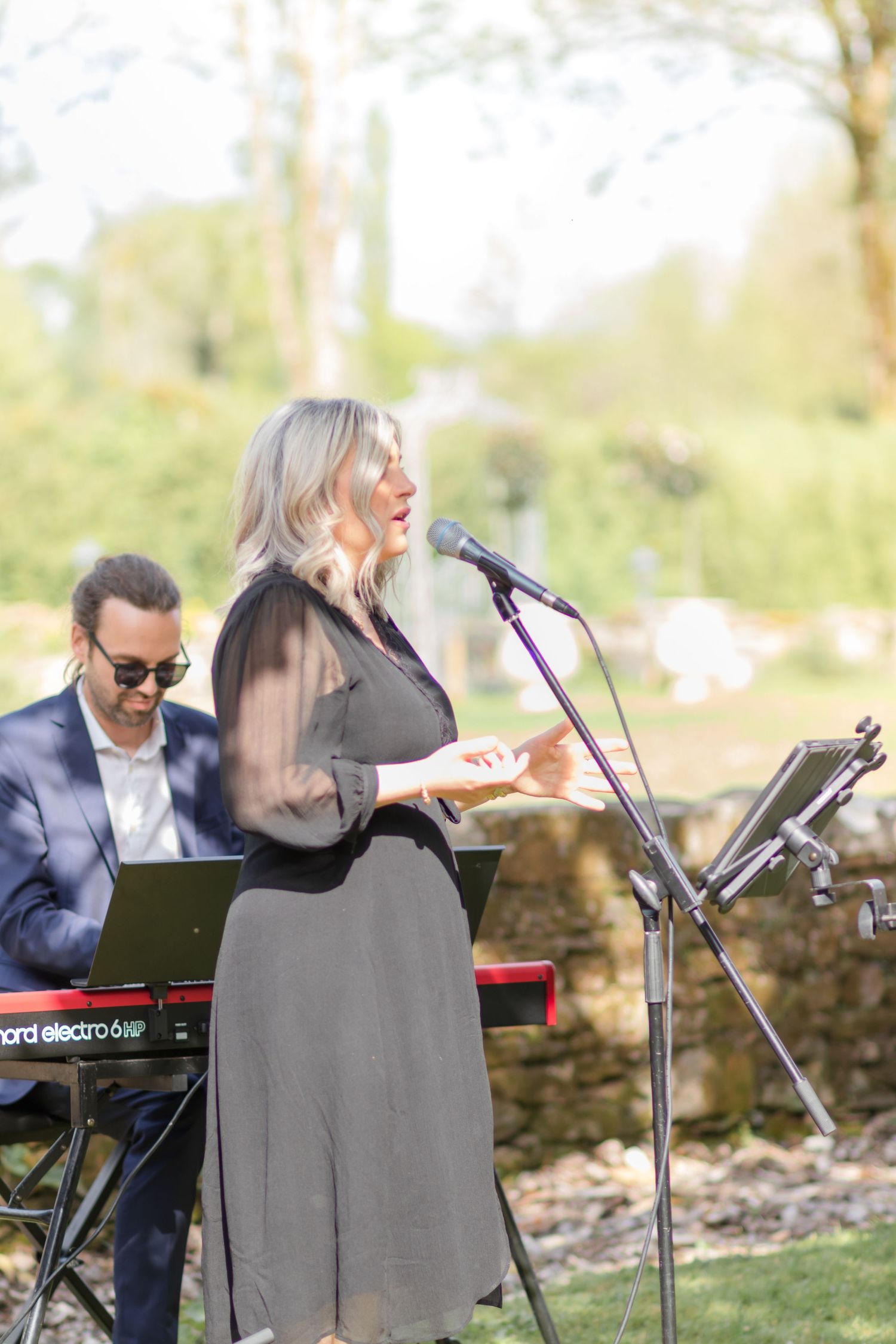 Live musical performance with keyboard accompaniment in an outdoor garden setting.