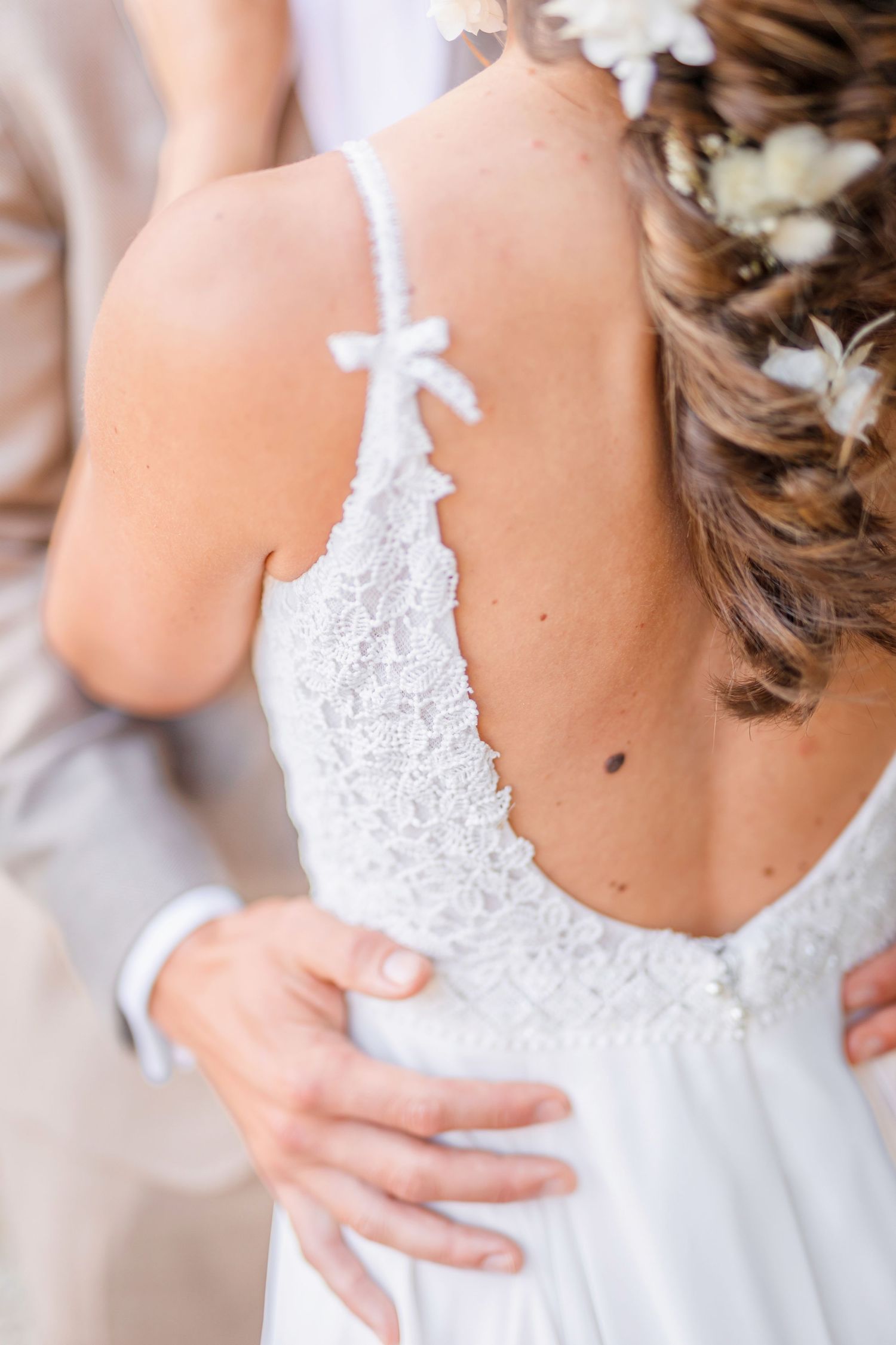 Detail shot of bridal dress showing delicate lace back and bow details.