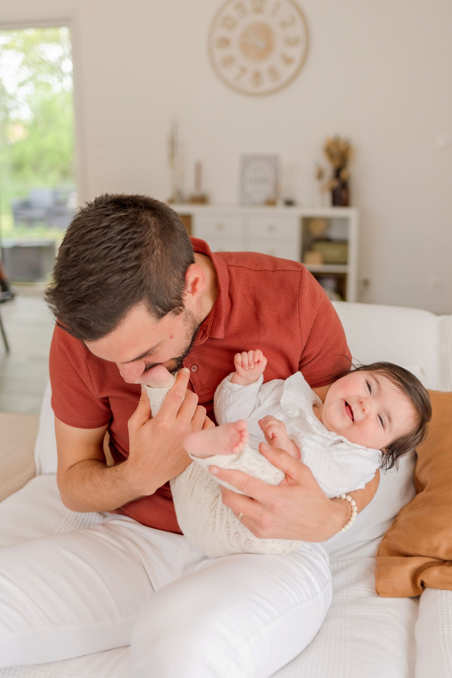 Sweet family moment shared on white bedding in a bright, minimalist room.