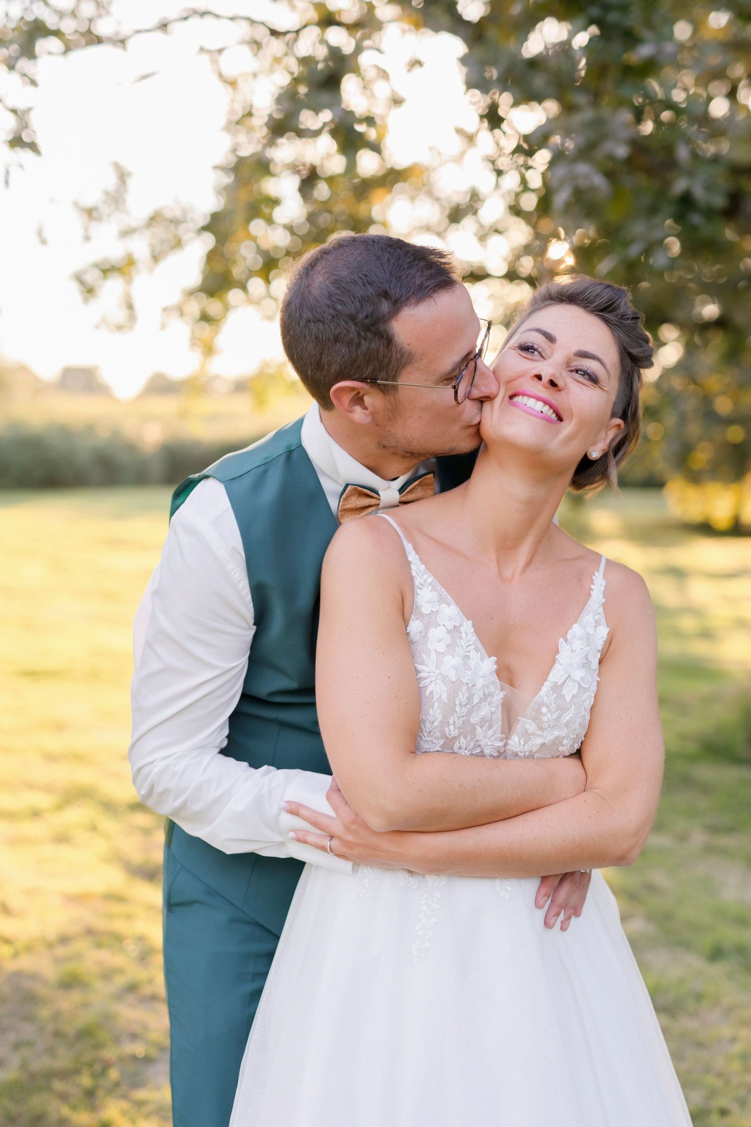 Romantic moment between a couple in wedding attire against golden sunset.