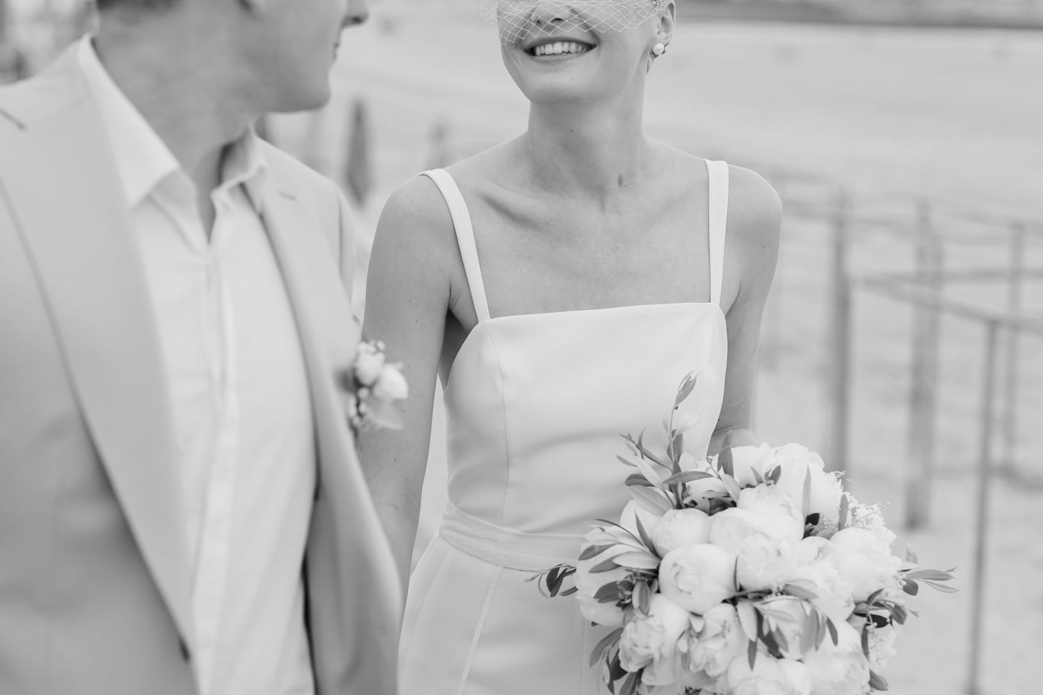 An intimate black and white wedding portrait with white floral bouquet.