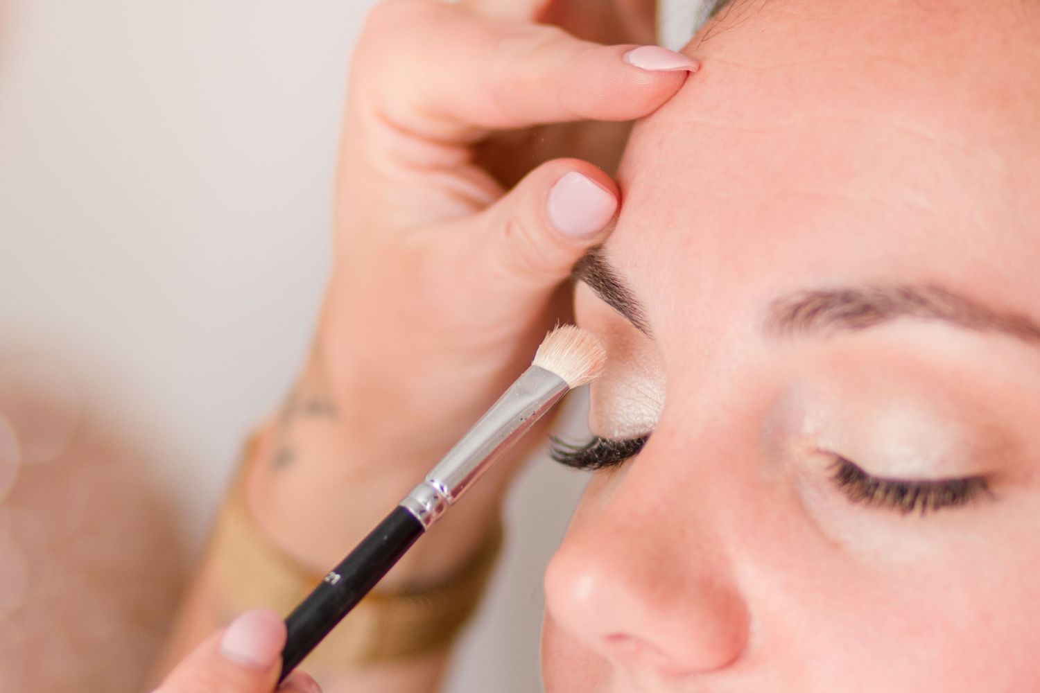 Detailed shot of eye makeup application using a precise brush technique.