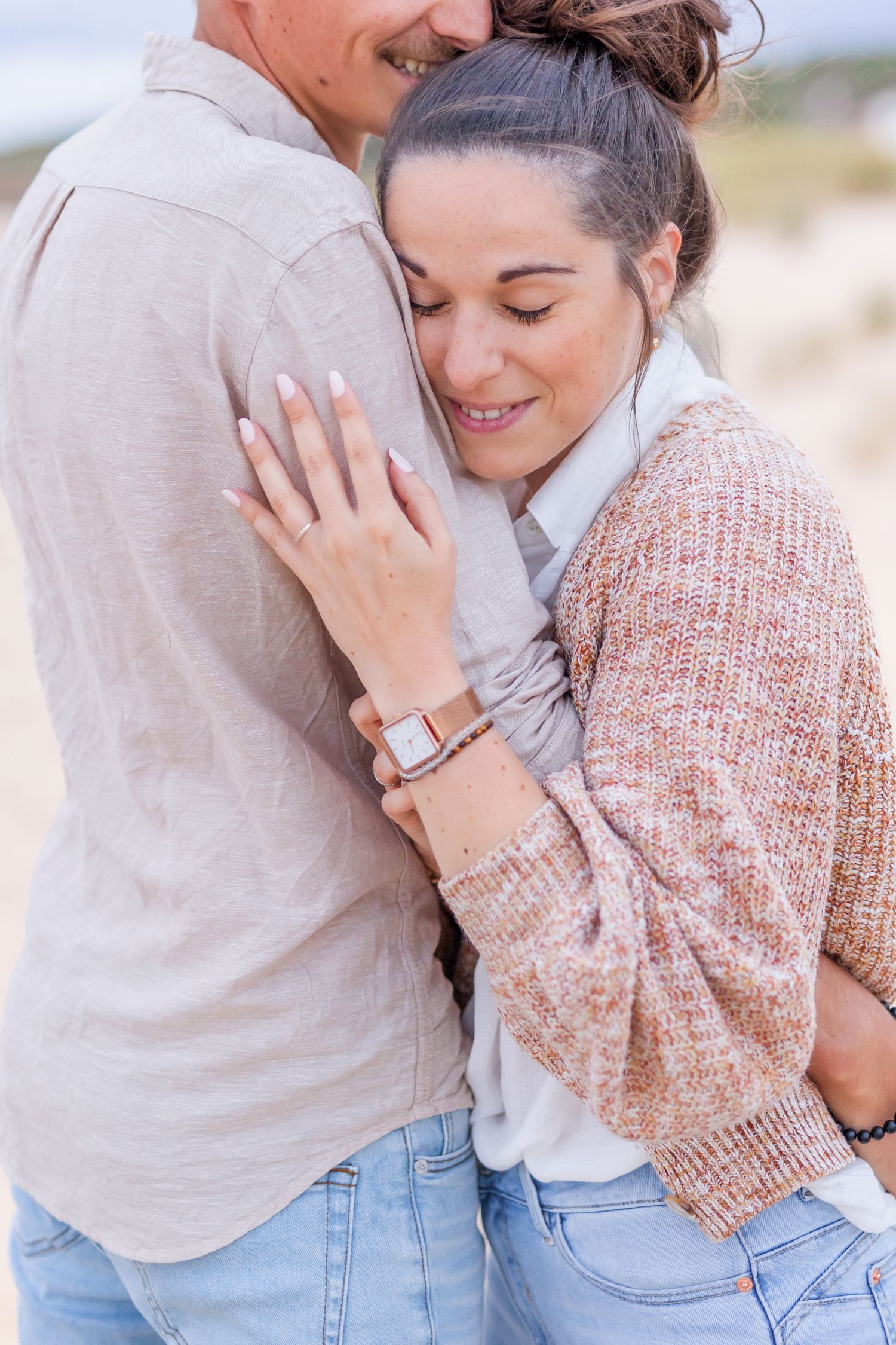 Sweet candid moments captured between couple in matching casual beach attire.