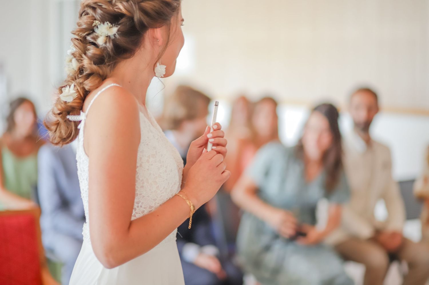 Indoor wedding ceremony setting with soft natural lighting and seated guests.