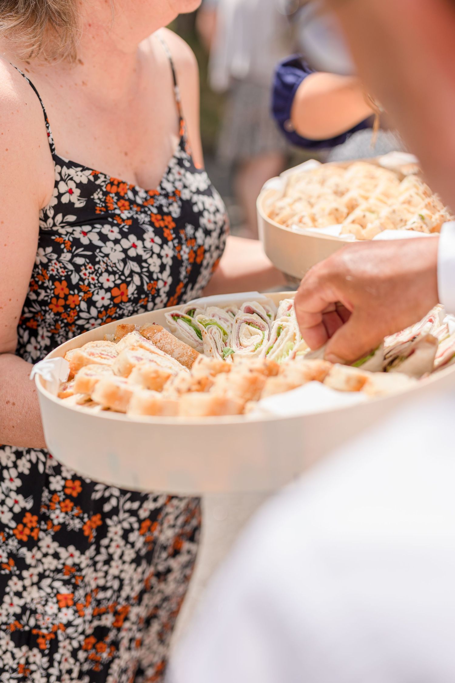 Close-up of catered food service with bowls of appetizers being served at outdoor event.