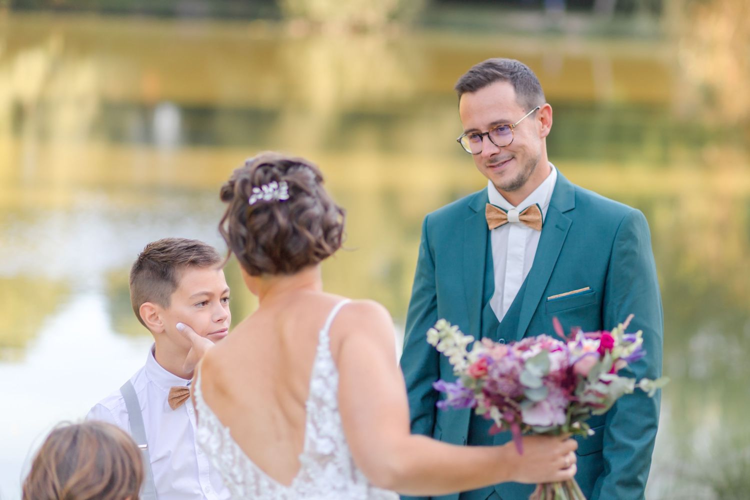 Outdoor wedding ceremony with lake backdrop and beautiful bouquet.
