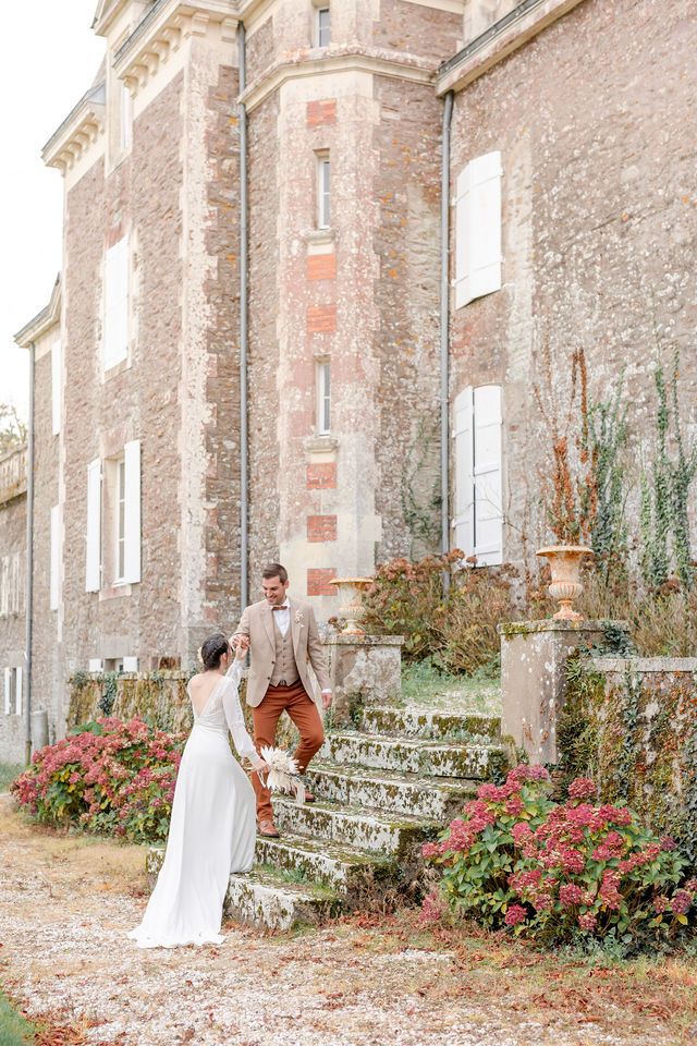 A romantic moment on vintage stone steps adorned with red flowers at a historic French chateau.