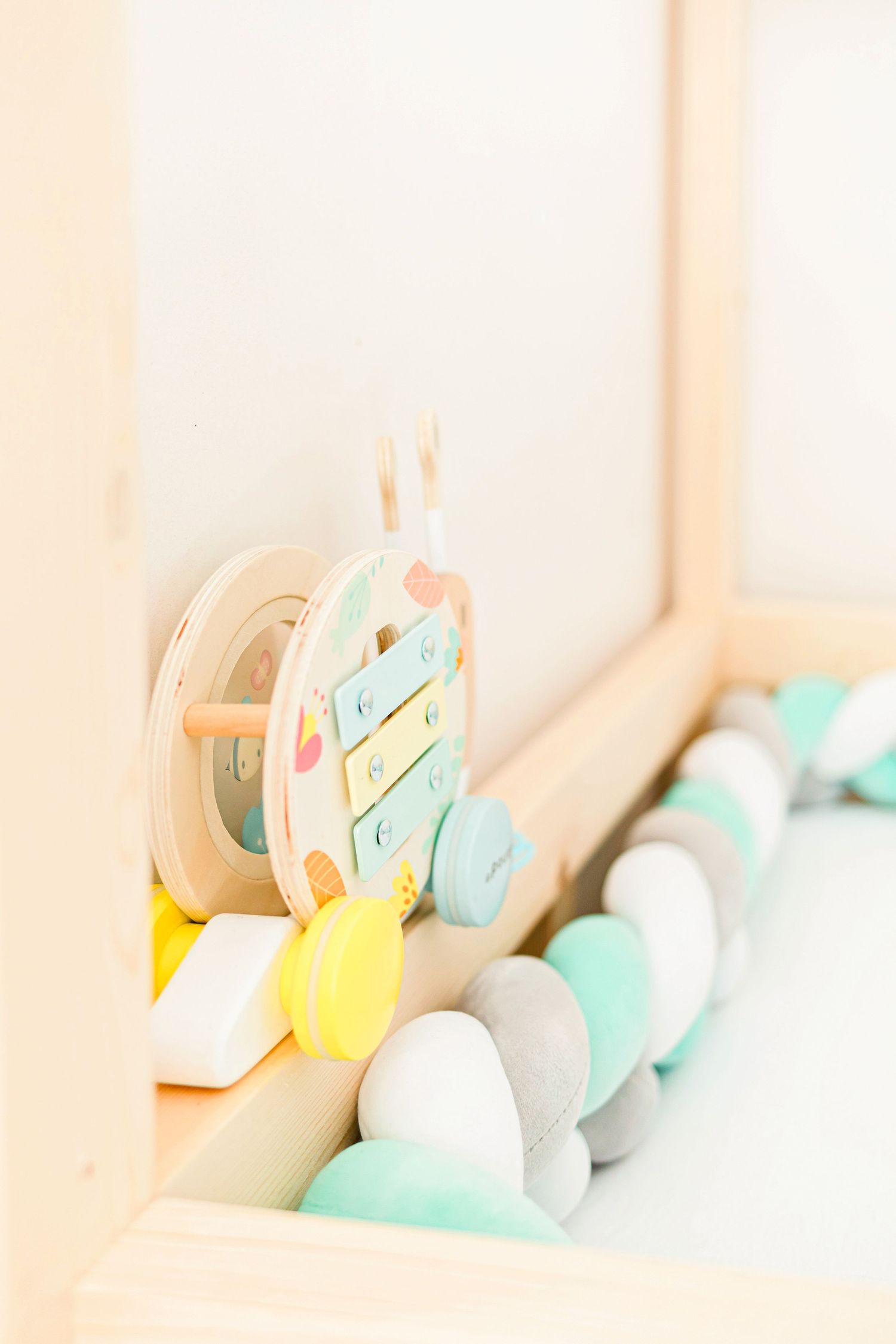 Pastel colored easter eggs and decorative items arranged on a shelf.