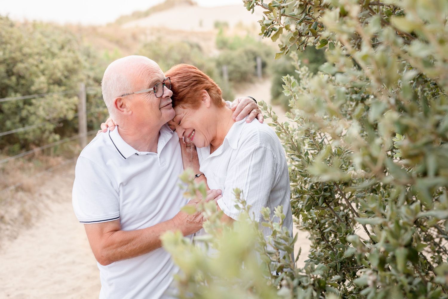 Family portrait session in a natural outdoor setting with desert hills and brush in the background.