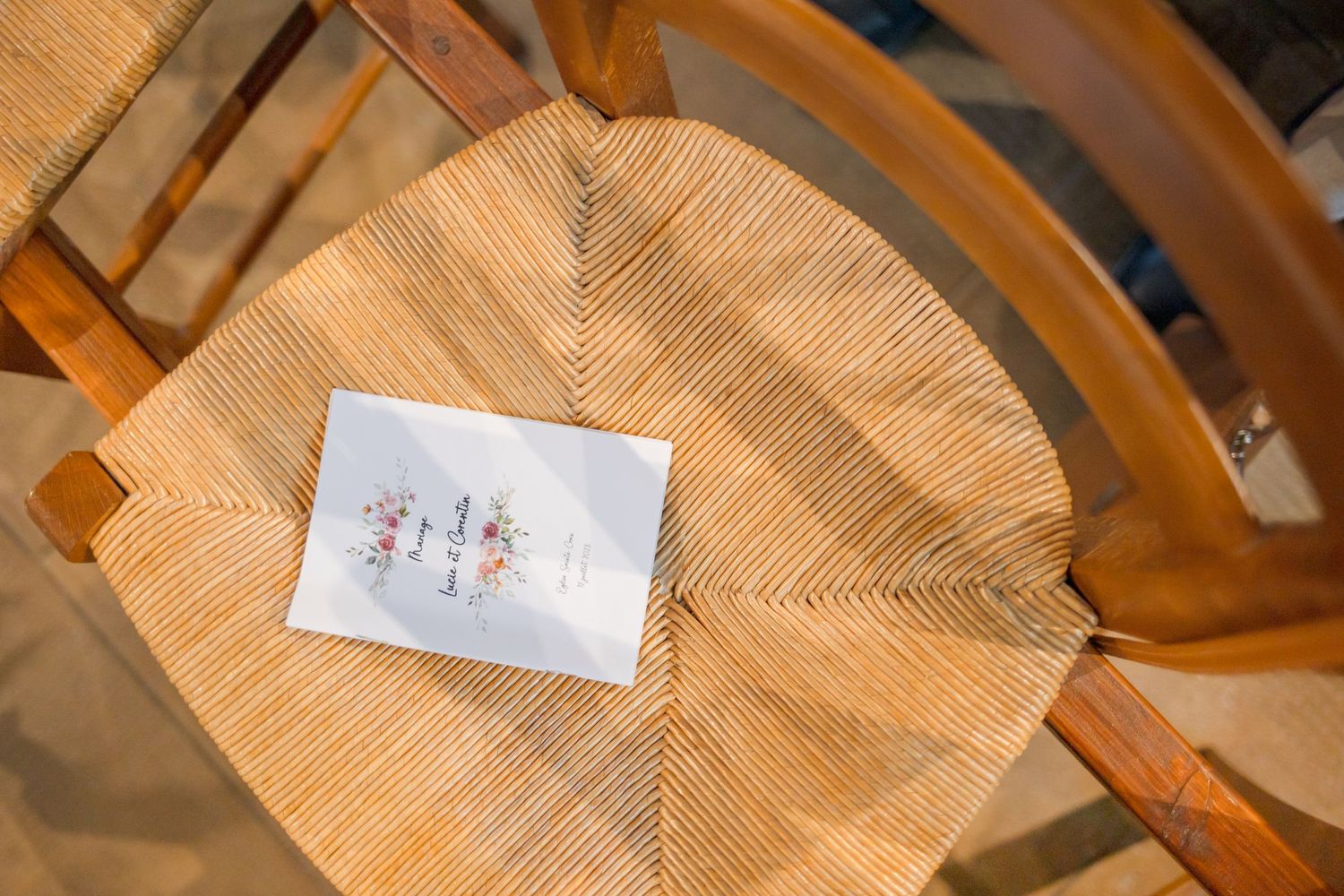 A small card resting on a woven wooden chair seat.