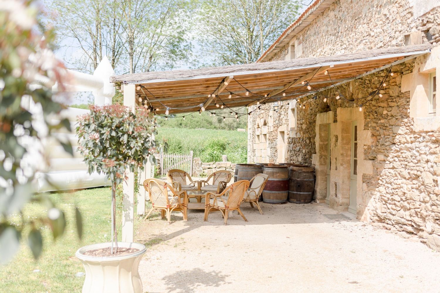 A scenic stone patio with rustic wooden beams overlooks a lush garden landscape.