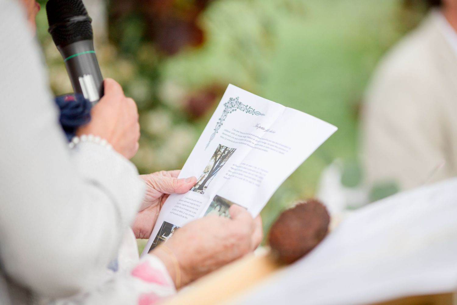 Attendees hold programs during an outdoor ceremony.